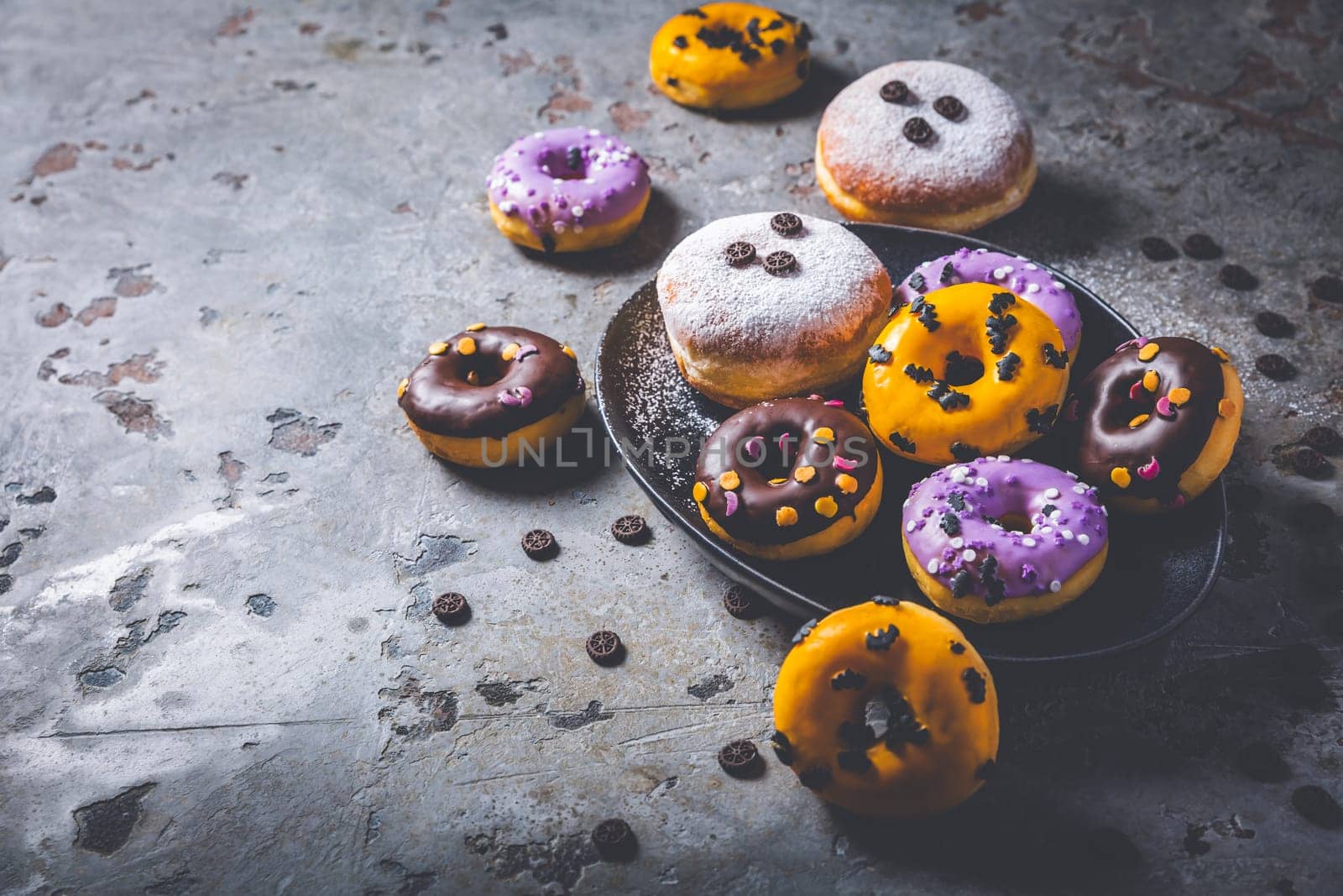 Halloween donuts and Berliner with assorted frosting and sugar sprinkles for Halloween and carnival