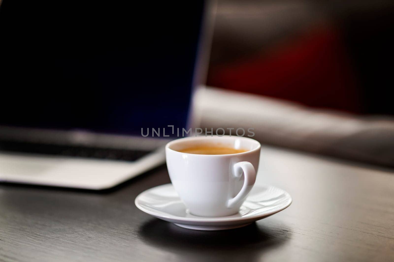 cup of coffee and laptop on wooden table