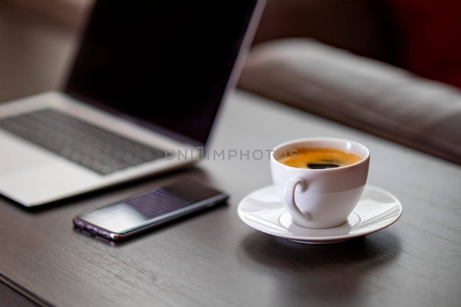 cup of coffee and laptop on wooden table