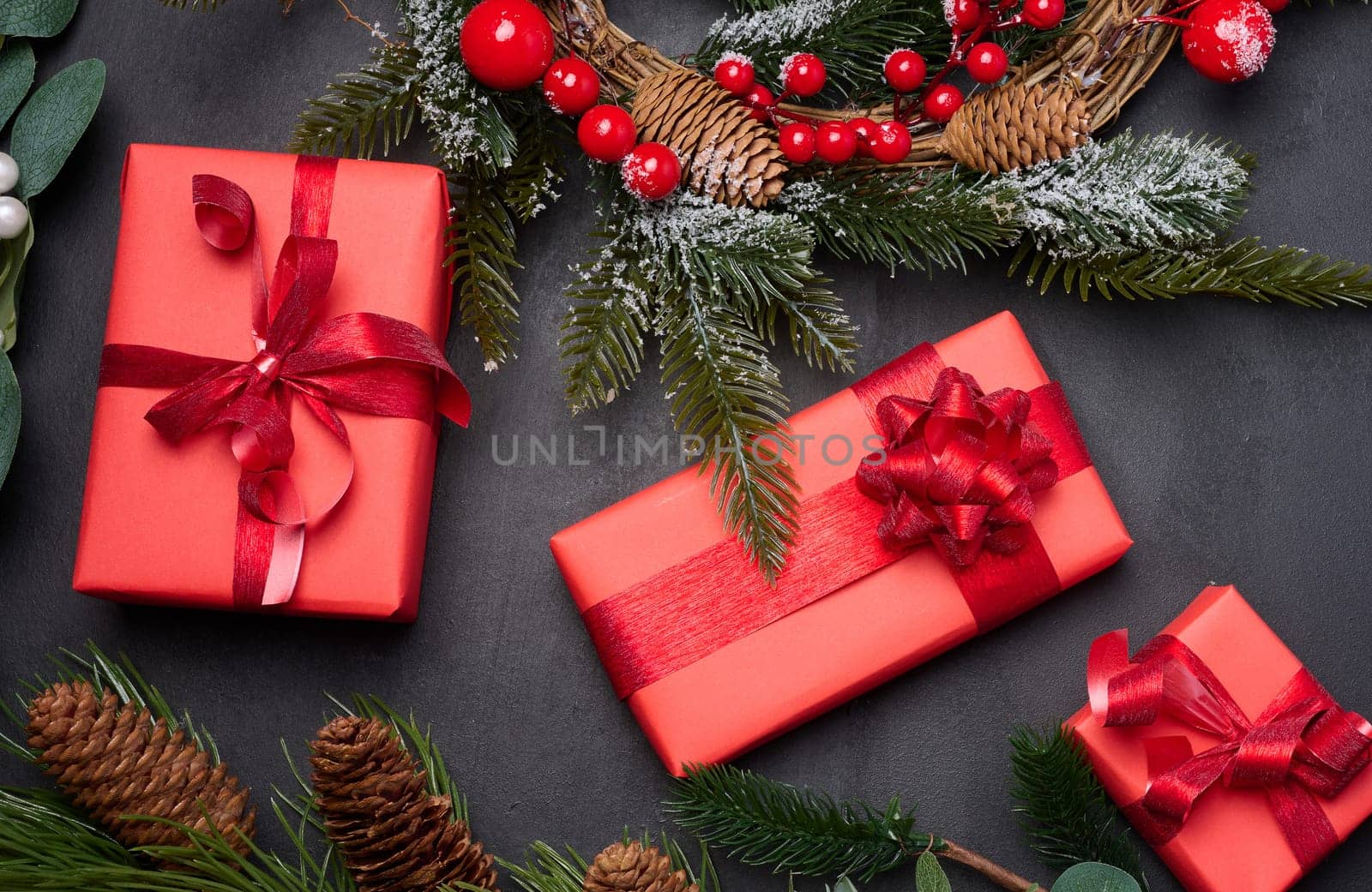 Christmas wreaths, fir branches and gifts on a black background. View from above