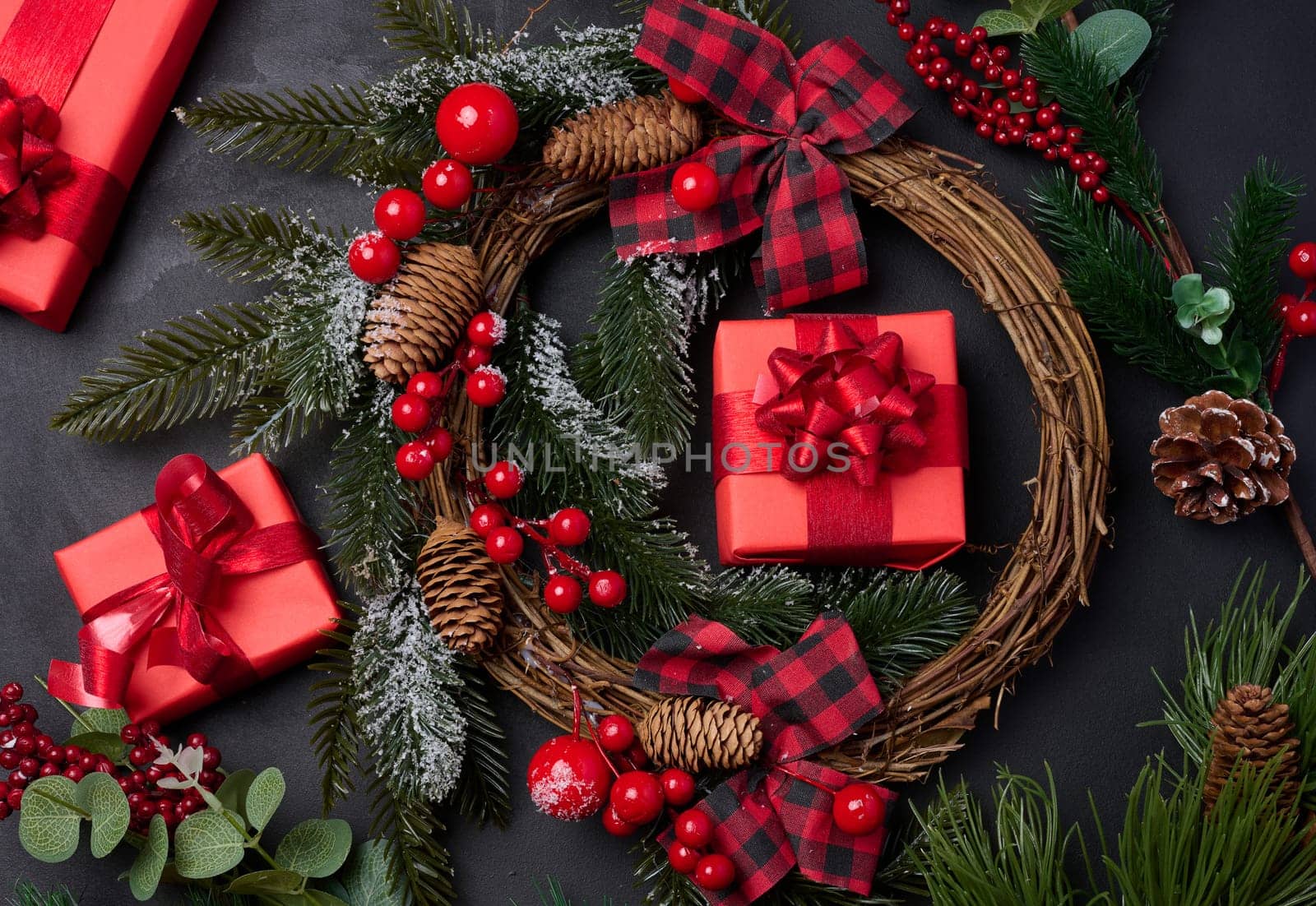 Christmas wreaths, fir branches and gifts on a black background. View from above