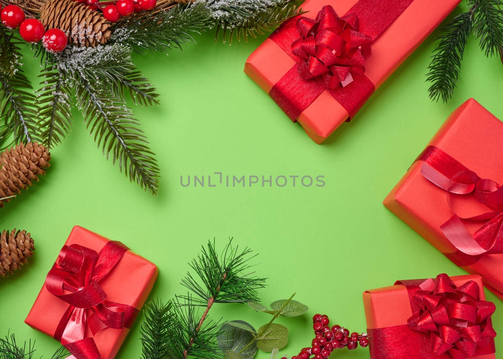 Christmas decor, gifts wrapped in red paper on a green background, top view