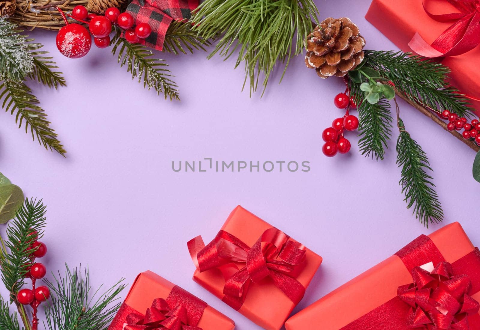 Christmas decor, gifts wrapped in red paper on a purple background, top view