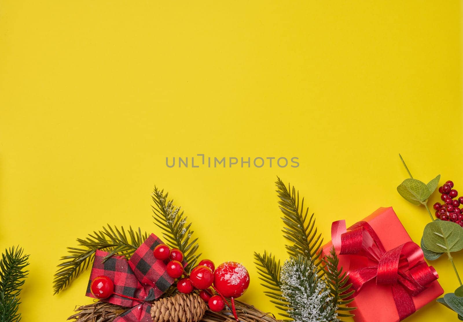 Christmas decor, gifts wrapped in red paper on a yellow background, top view. Copy space