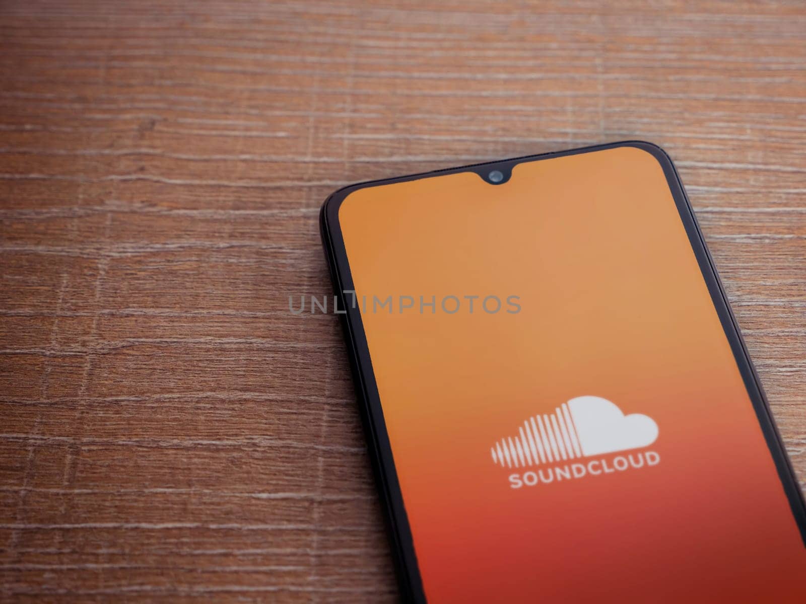 Lod, Israel - July 16,2023: SoundCloud app launch screen on smartphone on wooden background. Top view flat lay with copy space.