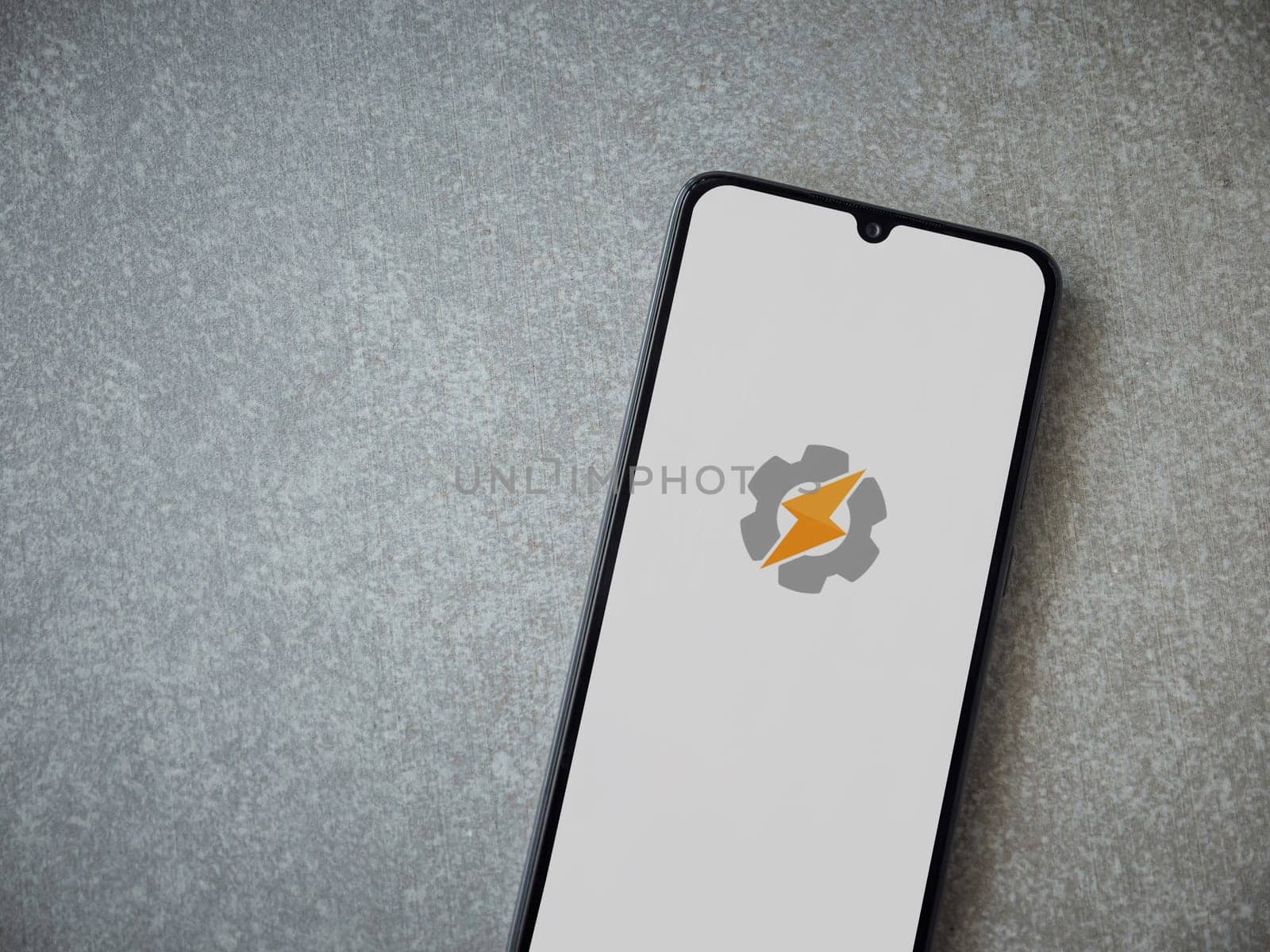 Lod, Israel - July 16,2023: Tasker app launch screen on smartphone on ceramic stone background. Top view flat lay with copy space.