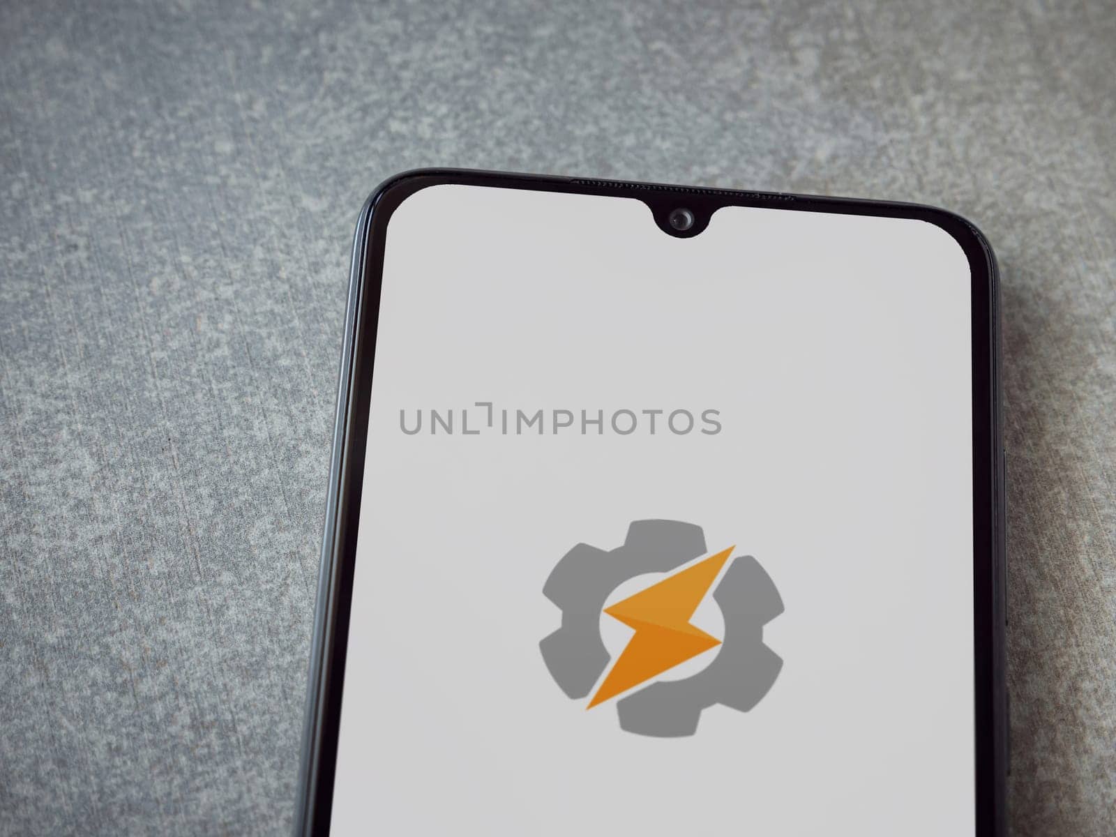 Lod, Israel - July 16,2023: Tasker app launch screen on smartphone on ceramic stone background. Top view flat lay with copy space.