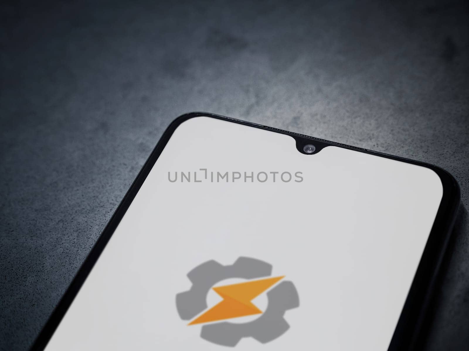 Lod, Israel - July 16,2023: Tasker app launch screen on smartphone on dark marble stone background. Top view flat lay with copy space.