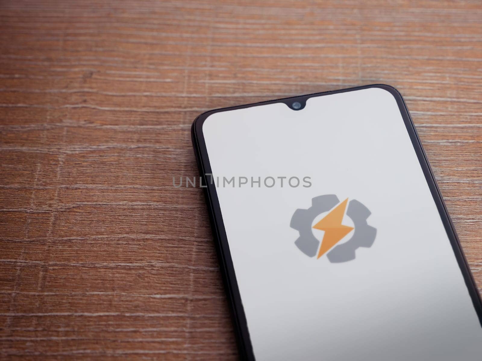 Lod, Israel - July 16,2023: Tasker app launch screen on smartphone on wooden background. Top view flat lay with copy space.