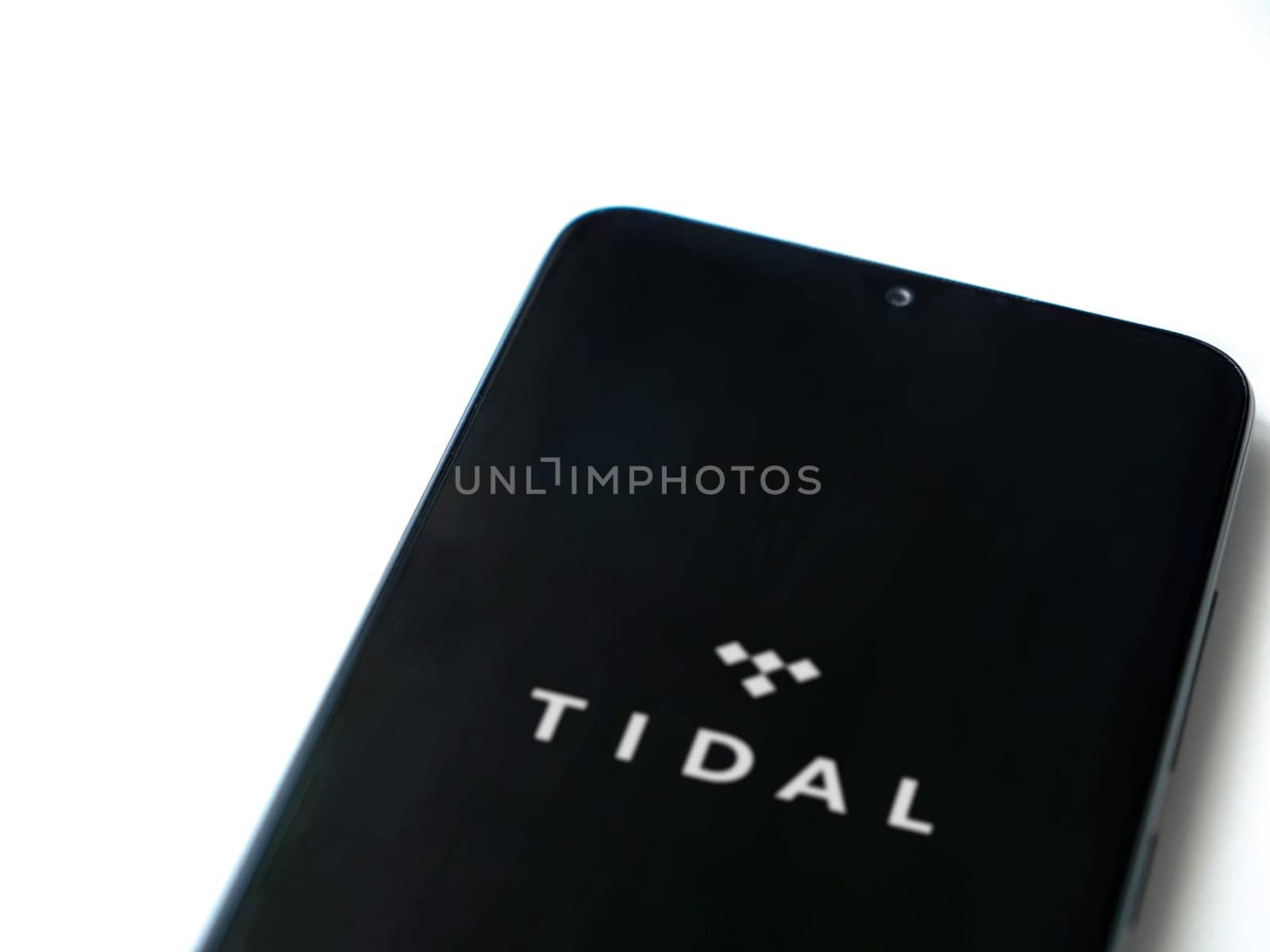 Lod, Israel - July 16,2023: TIDAL Music app launch screen on smartphone on white background. Top view flat lay with copy space.