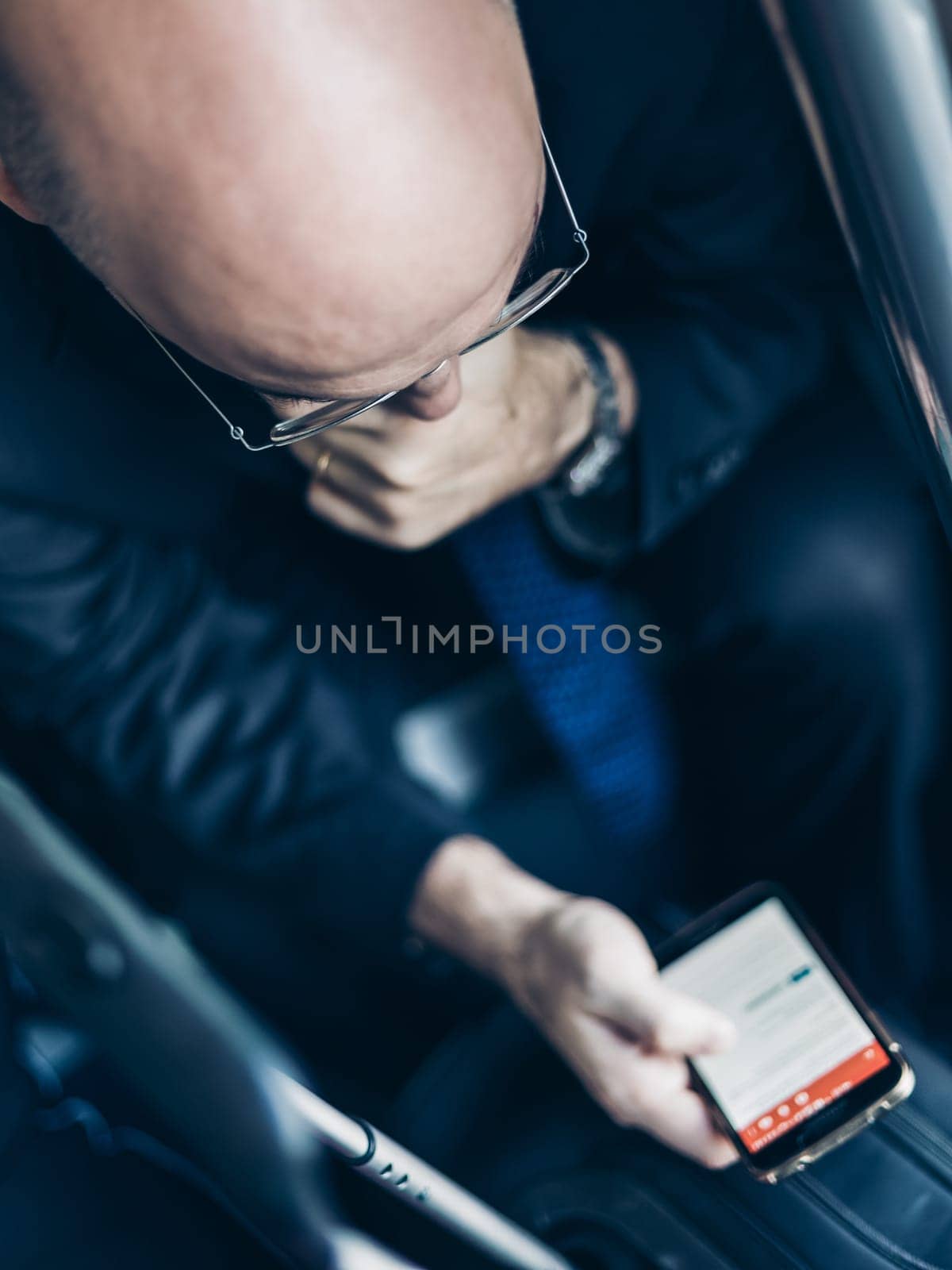 Businessman using his cell phones on subway. Business travel and communication concept. view from above. Vertical composition.