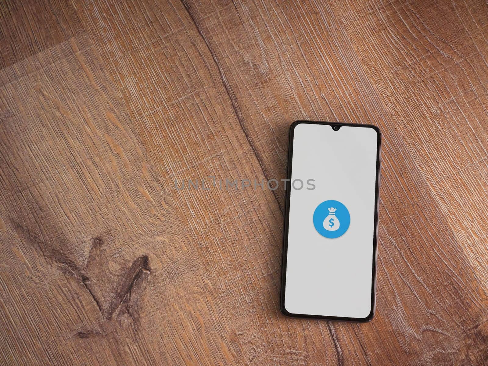 Lod, Israel - July 16,2023: Spender app launch screen on smartphone on wooden background. Top view flat lay with copy space.