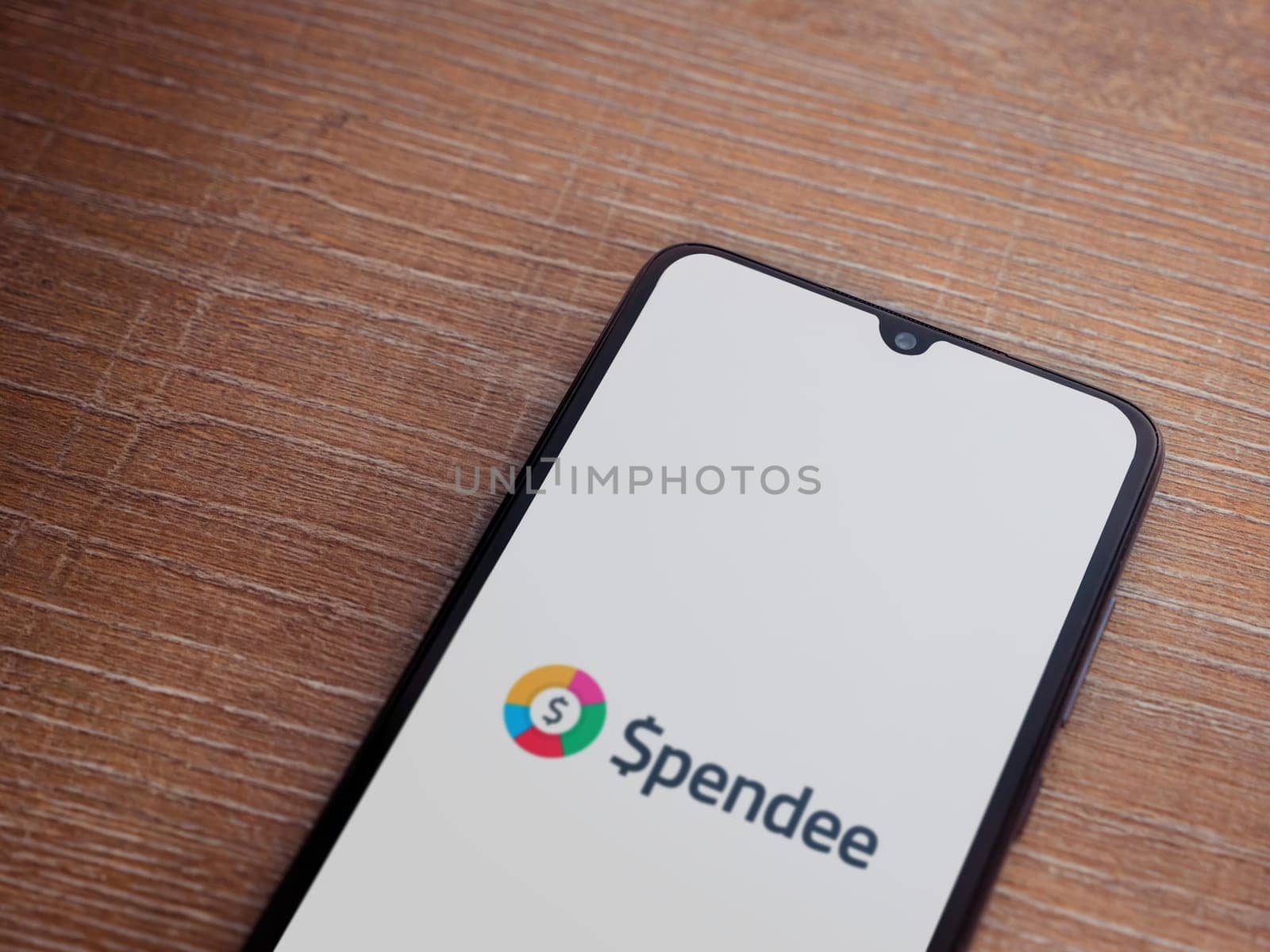 Lod, Israel - July 16,2023: Spendee app launch screen on smartphone on wooden background. Top view flat lay with copy space.