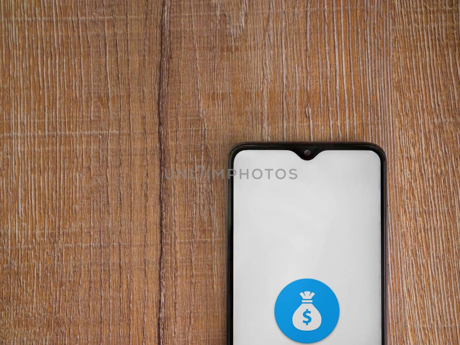 Lod, Israel - July 16,2023: Spender app launch screen on smartphone on wooden background. Top view flat lay with copy space.