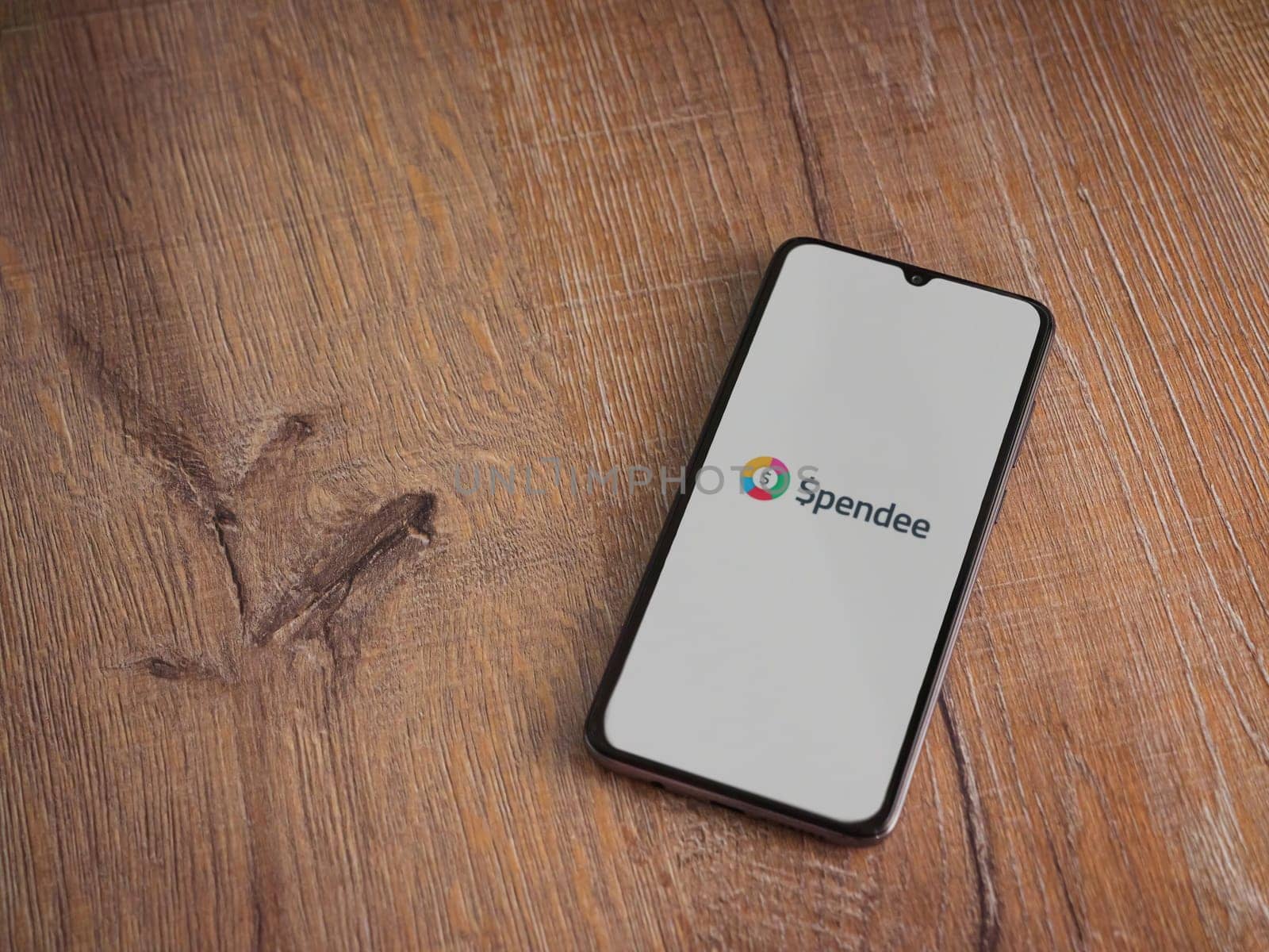 Lod, Israel - July 16,2023: Spendee app launch screen on smartphone on wooden background. Top view flat lay with copy space.
