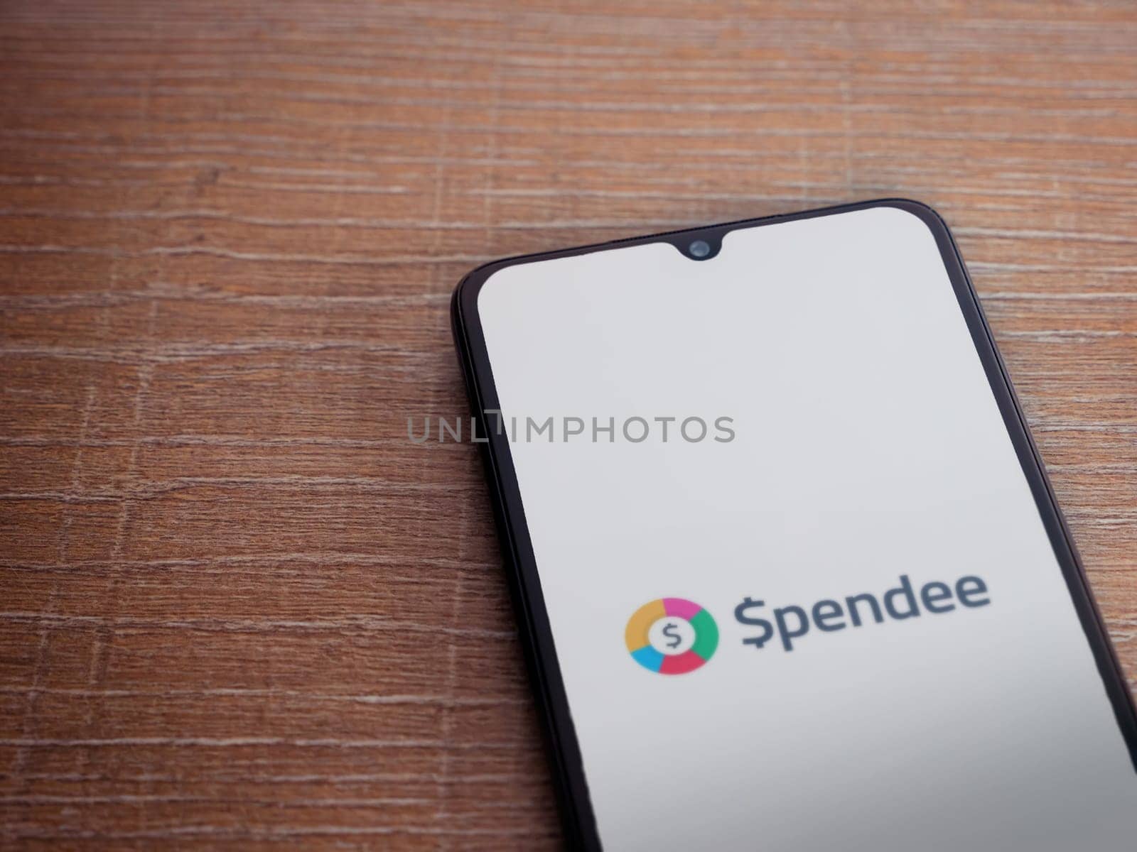 Lod, Israel - July 16,2023: Spendee app launch screen on smartphone on wooden background. Top view flat lay with copy space.