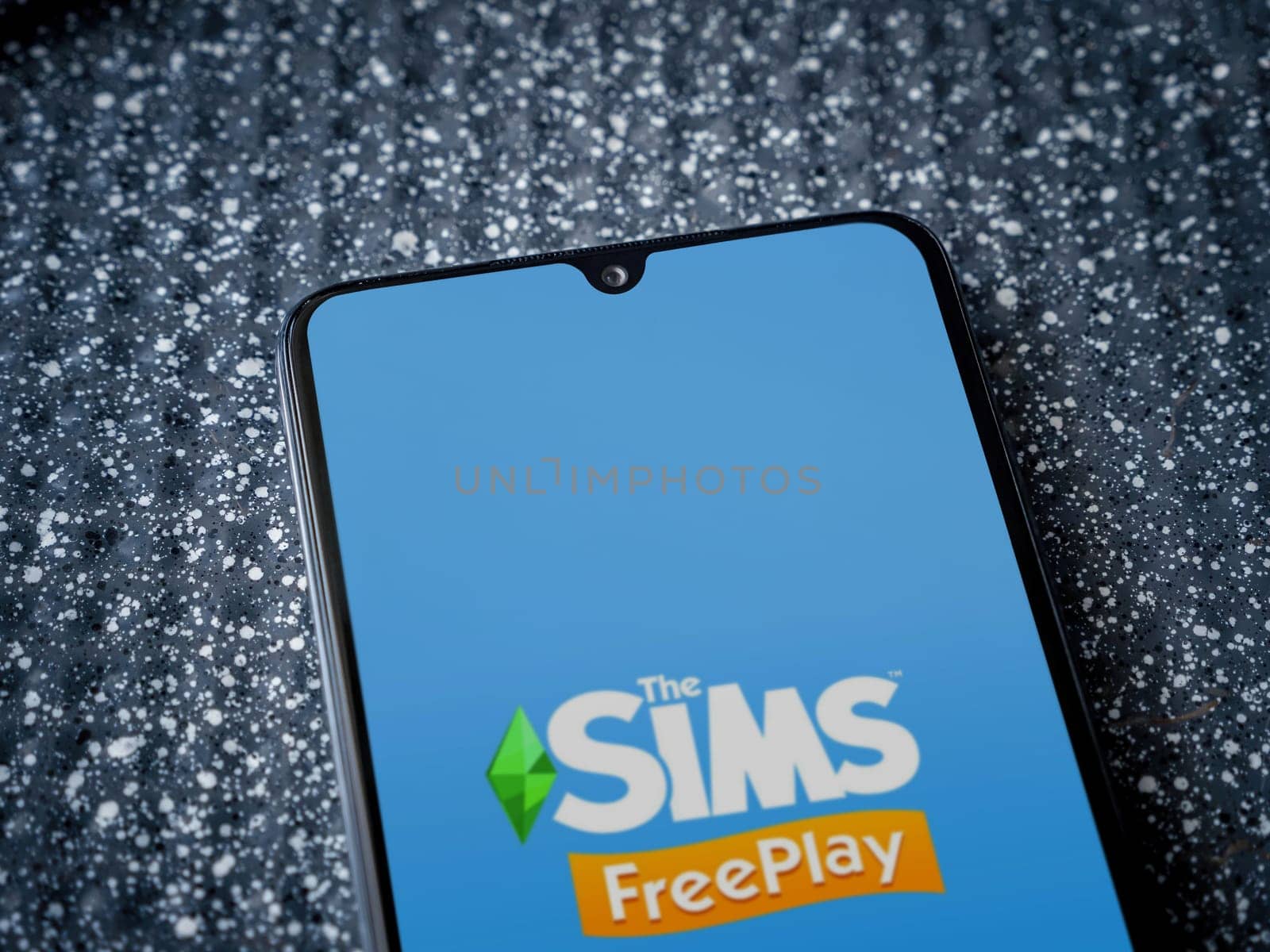 Lod, Israel - July 16,2023: The Sims FreePlay app launch screen on smartphone on metallic background. Close up top view flat lay.