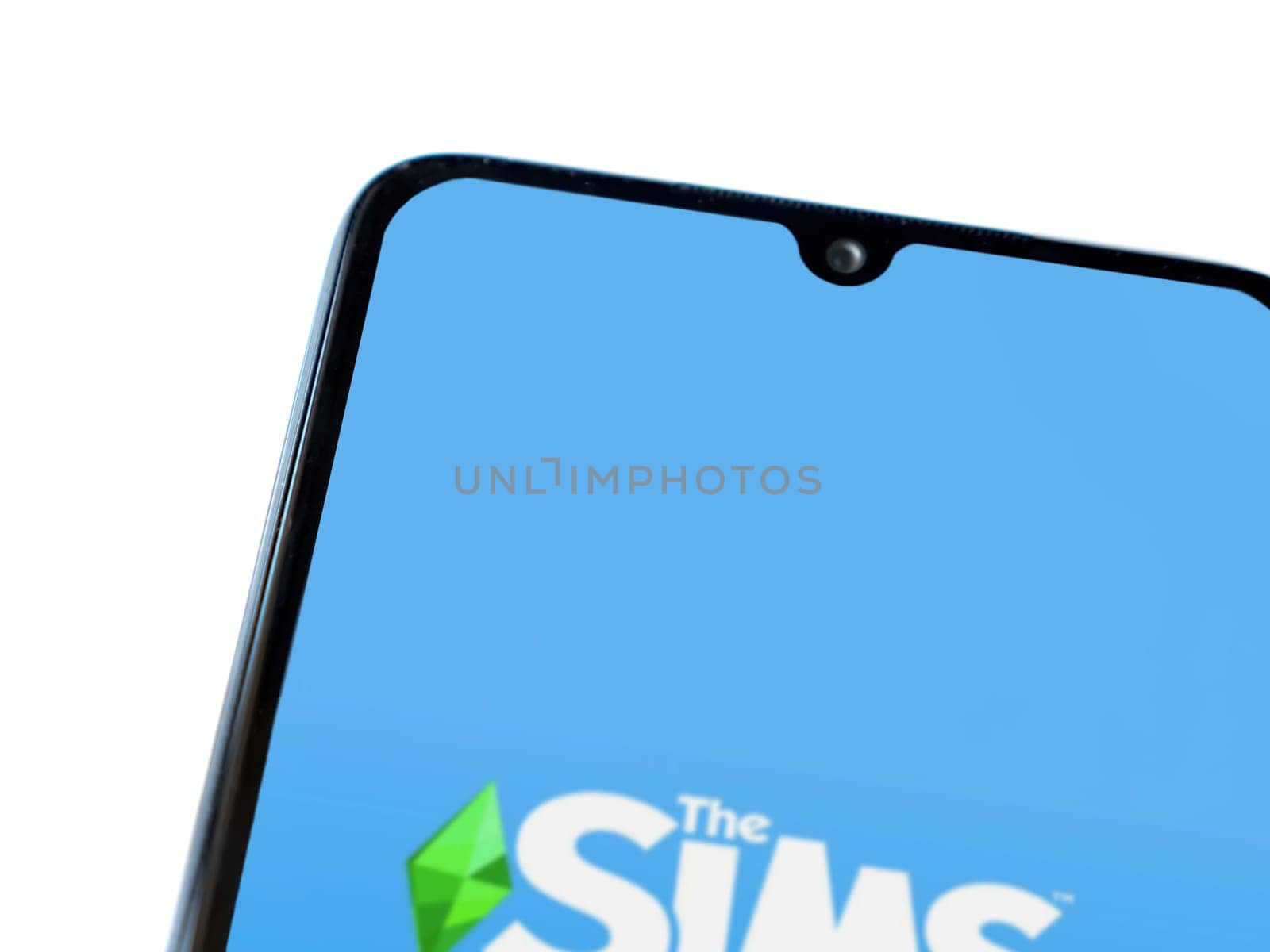 Lod, Israel - July 16,2023: The Sims FreePlay app launch screen on smartphone on white background. Top view flat lay with copy space.