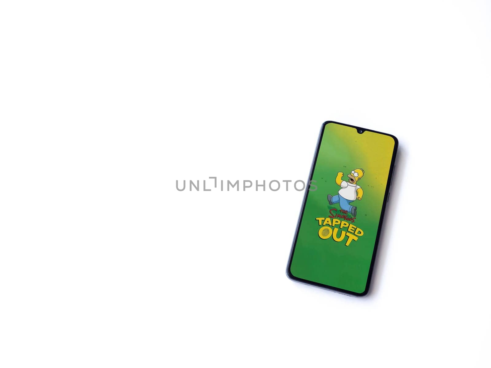 Lod, Israel - July 16,2023: The Simpsons Tapped Out app launch screen on smartphone on white background. Top view flat lay with copy space.