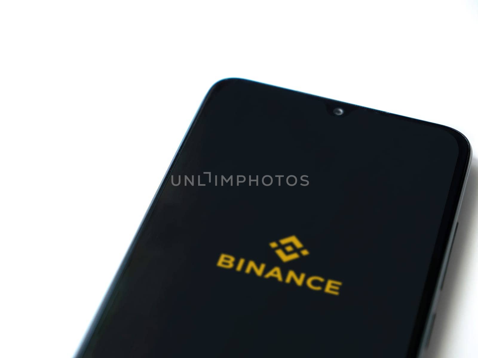 Lod, Israel - July 16,2023: Binance app launch screen on smartphone on white background. Top view flat lay with copy space.