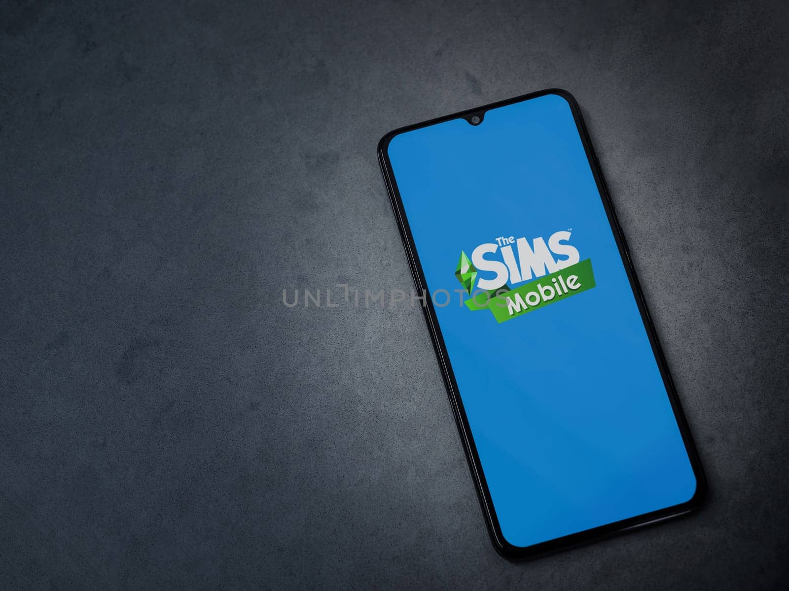 Lod, Israel - July 16,2023: The Sims Mobile app launch screen on smartphone on dark marble stone background. Top view flat lay with copy space.