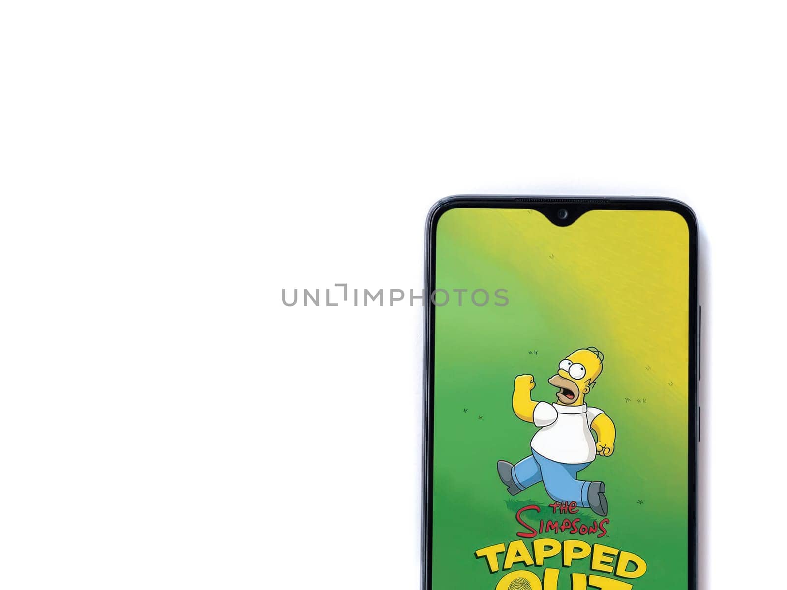 Lod, Israel - July 16,2023: The Simpsons Tapped Out app launch screen on smartphone on white background. Top view flat lay with copy space.