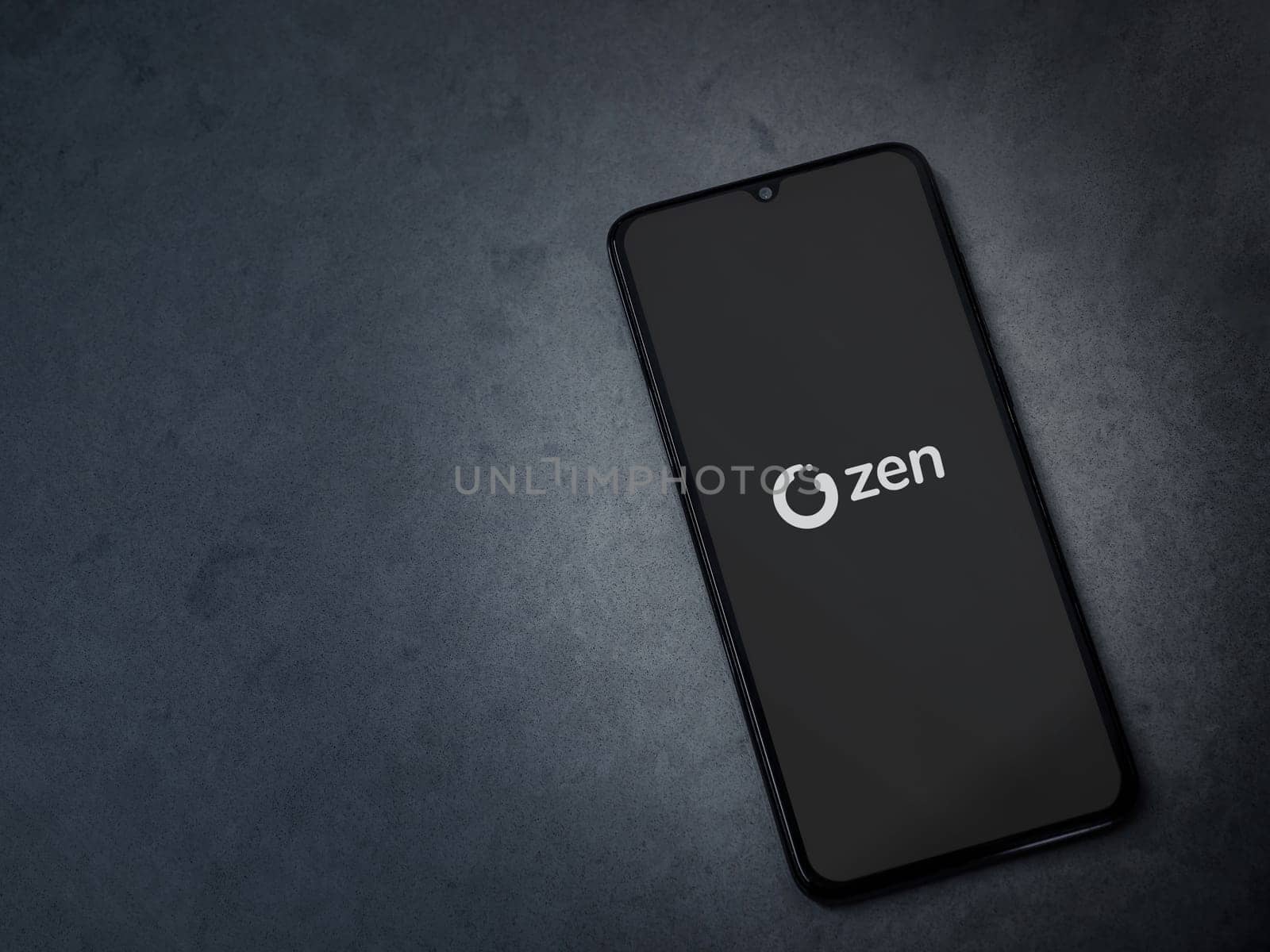 Lod, Israel - July 16,2023: ZEN.COM app launch screen on smartphone on dark marble stone background. Top view flat lay with copy space.