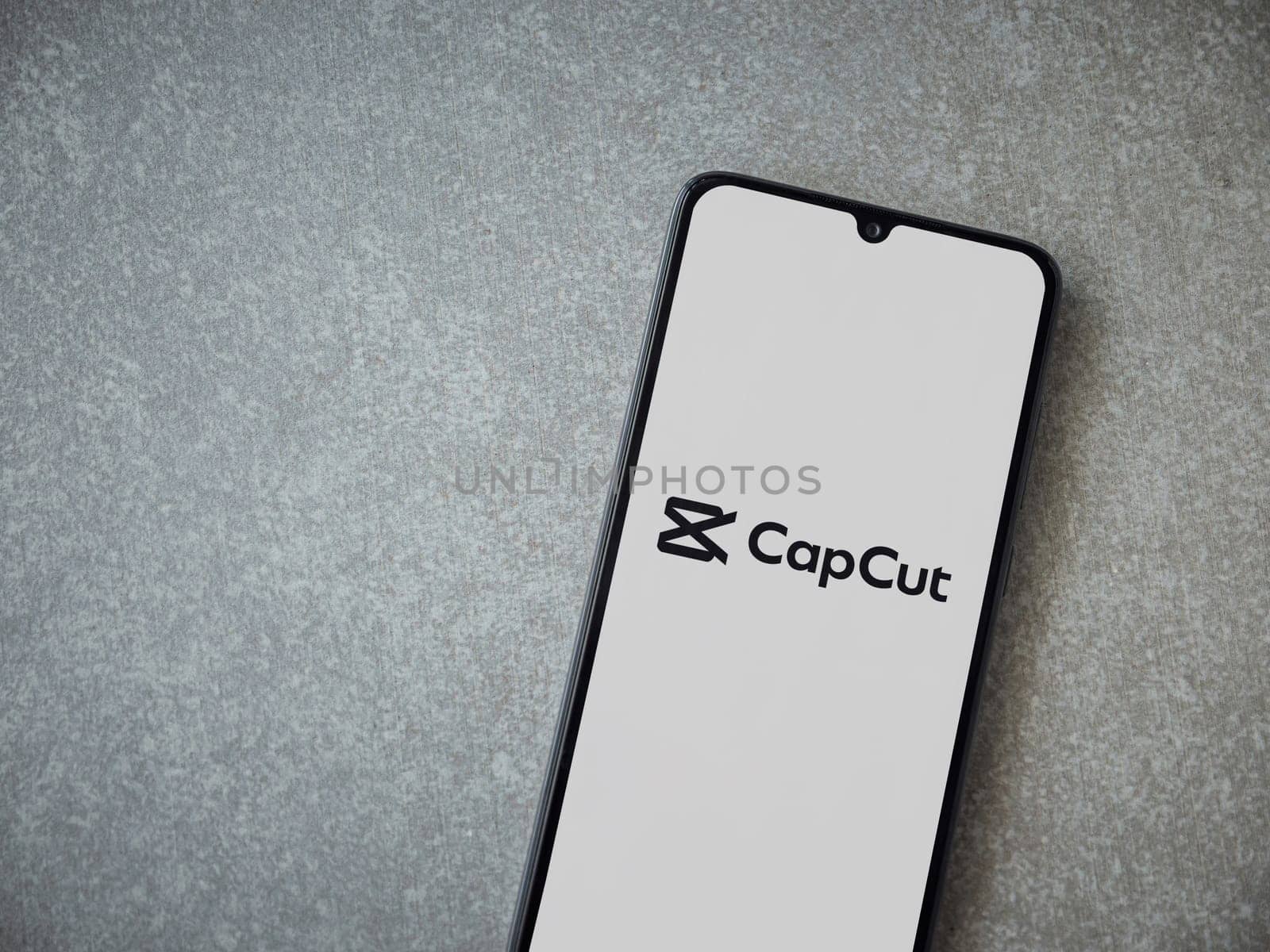 Lod, Israel - July 16,2023: CapCut app launch screen on smartphone on ceramic stone background.. Top view flat lay with copy space.