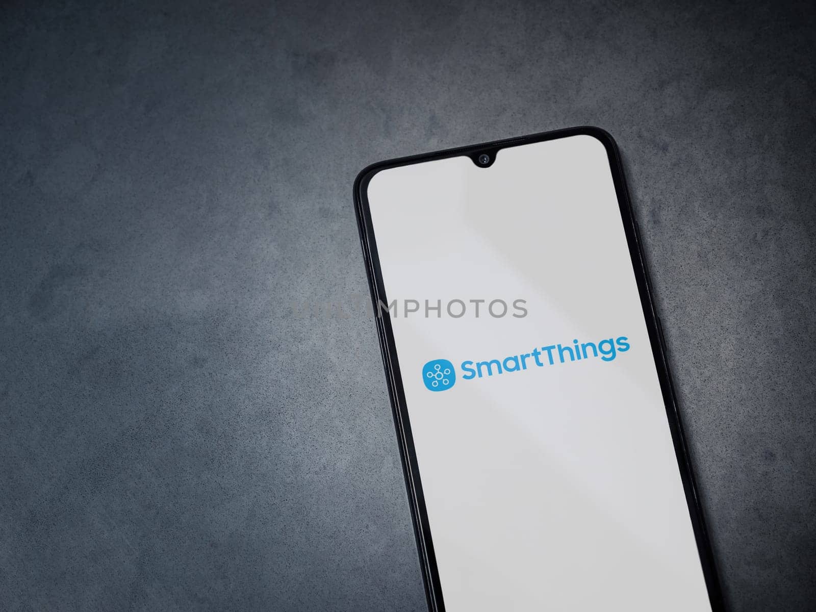 Lod, Israel - July 16,2023: Smartthings app launch screen on smartphone on dark marble stone background. Top view flat lay with copy space.