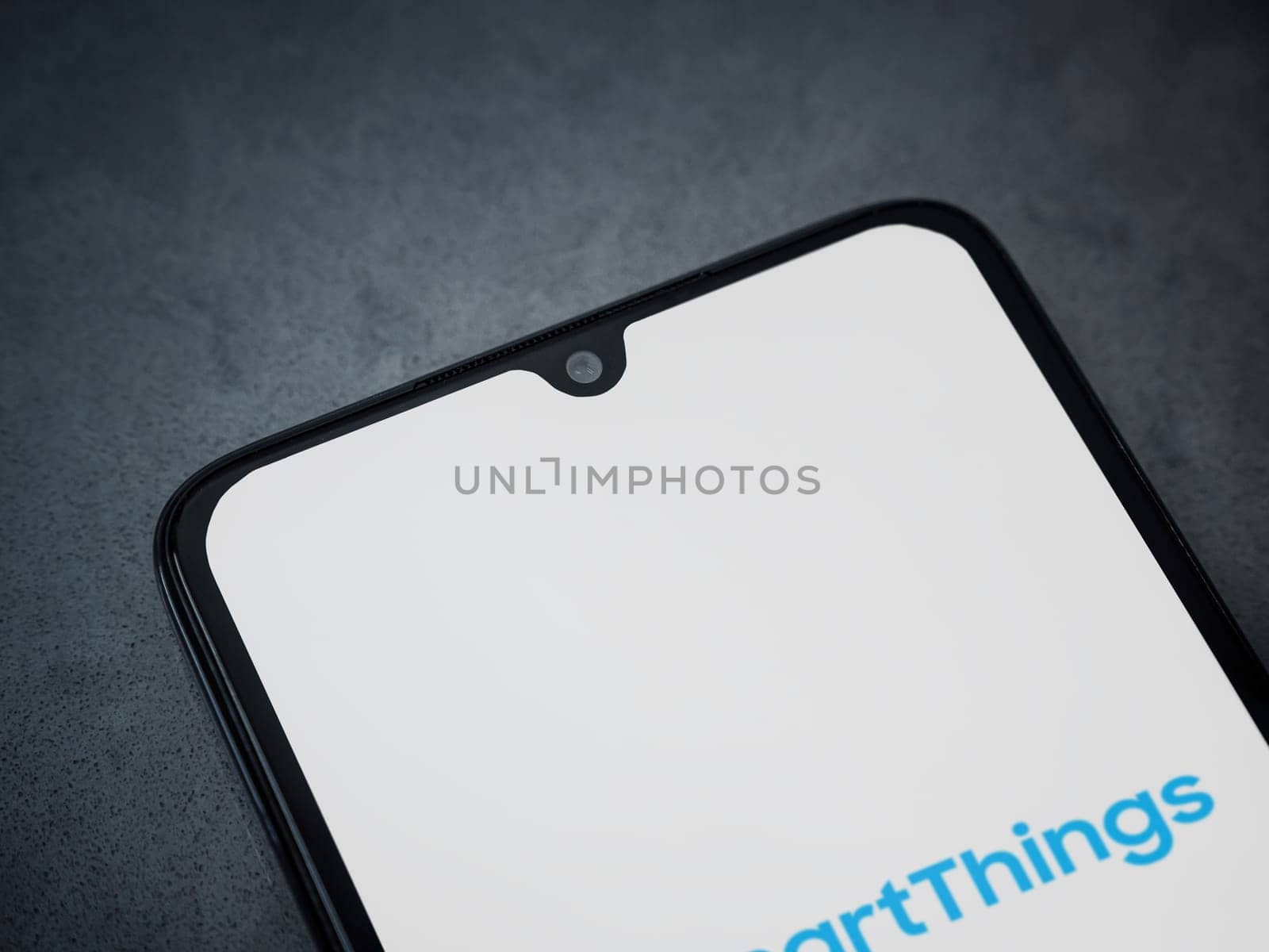 Lod, Israel - July 16,2023: Smartthings app launch screen on smartphone on dark marble stone background. Top view flat lay with copy space.