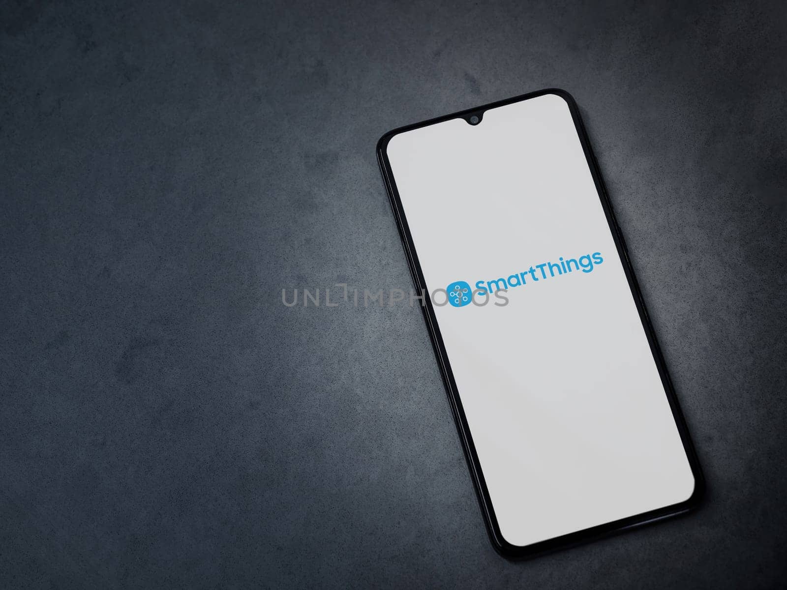 Lod, Israel - July 16,2023: Smartthings app launch screen on smartphone on dark marble stone background. Top view flat lay with copy space.