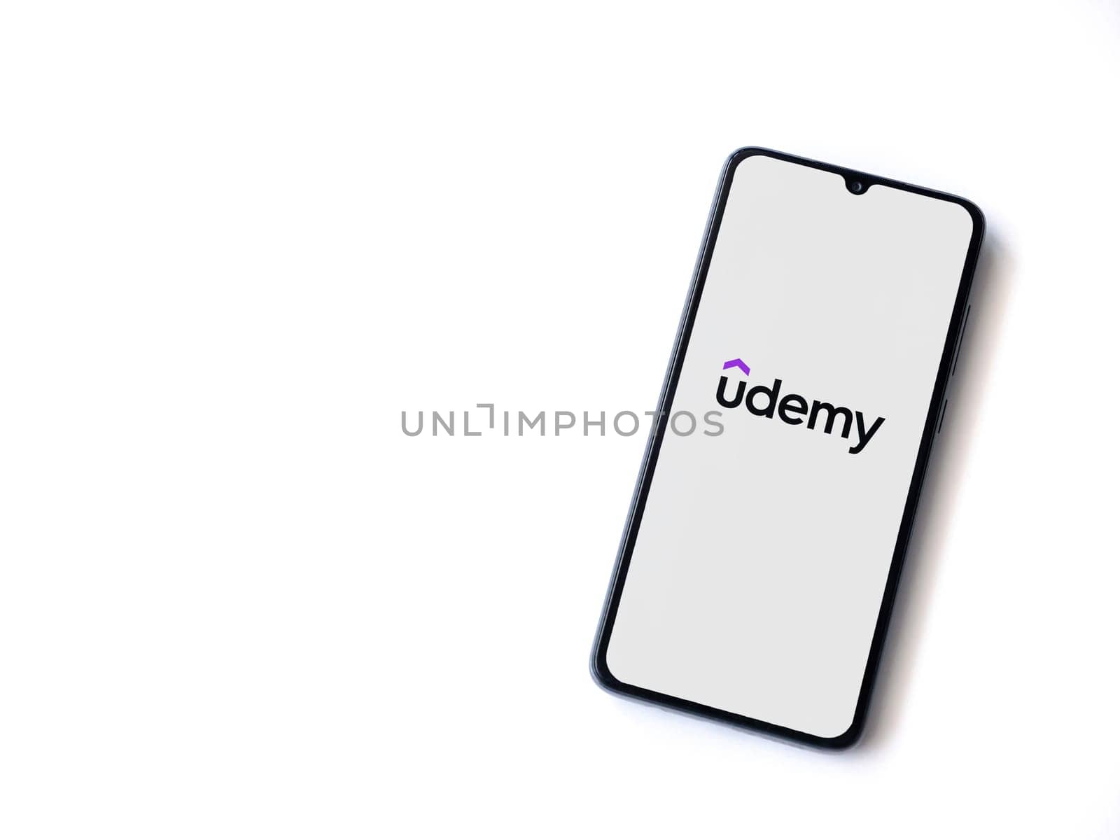 Lod, Israel - July 16,2023: Udemy app launch screen on smartphone on white background. Top view flat lay with copy space.