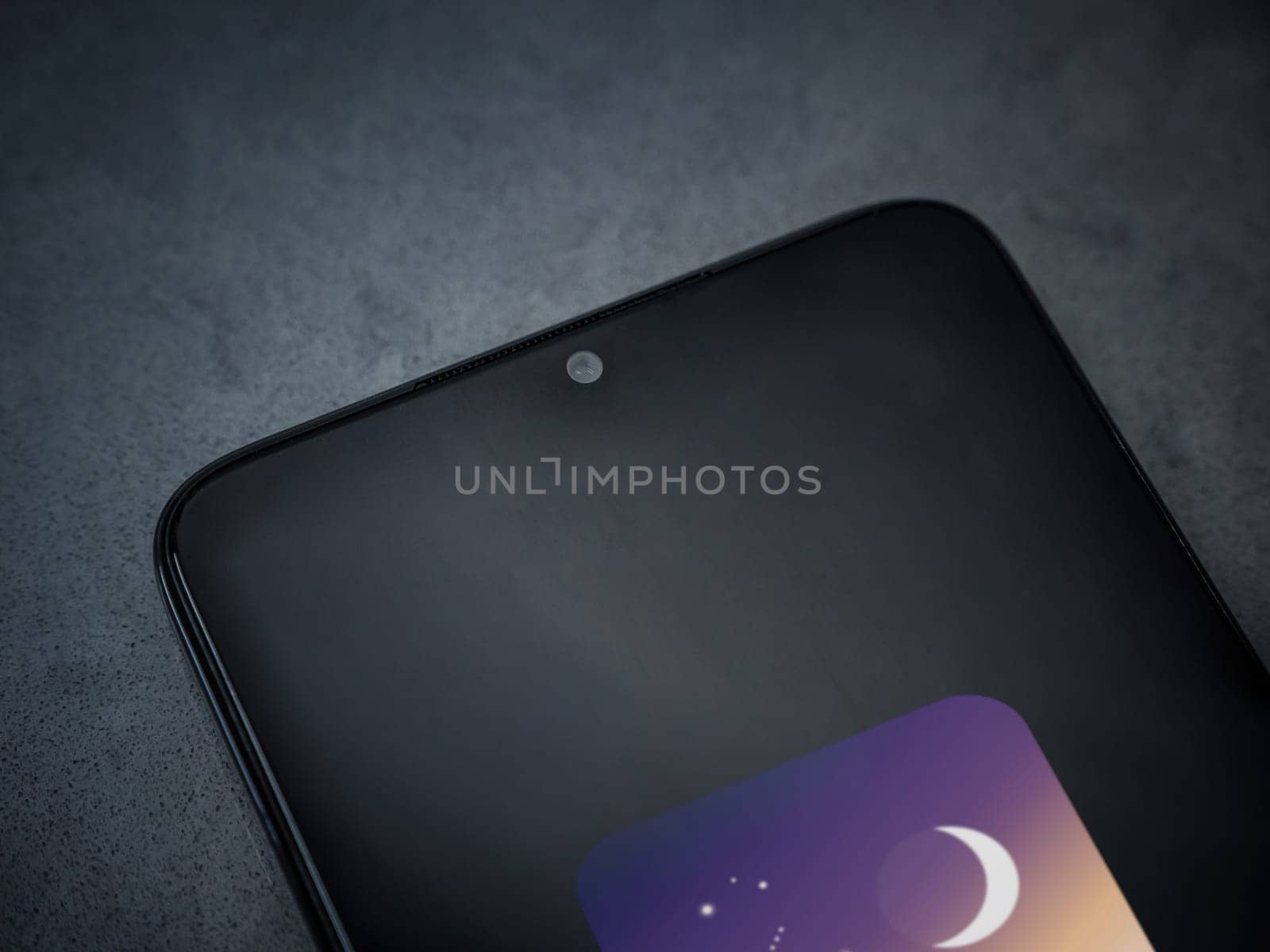 Lod, Israel - July 16,2023: Stellarium - Star Map app launch screen on smartphone on dark marble stone background. Top view flat lay with copy space.