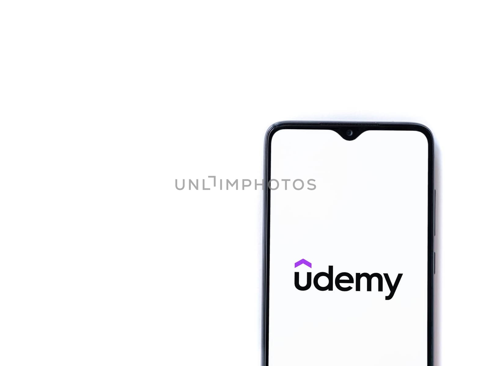 Lod, Israel - July 16,2023: Udemy app launch screen on smartphone on white background. Top view flat lay with copy space.