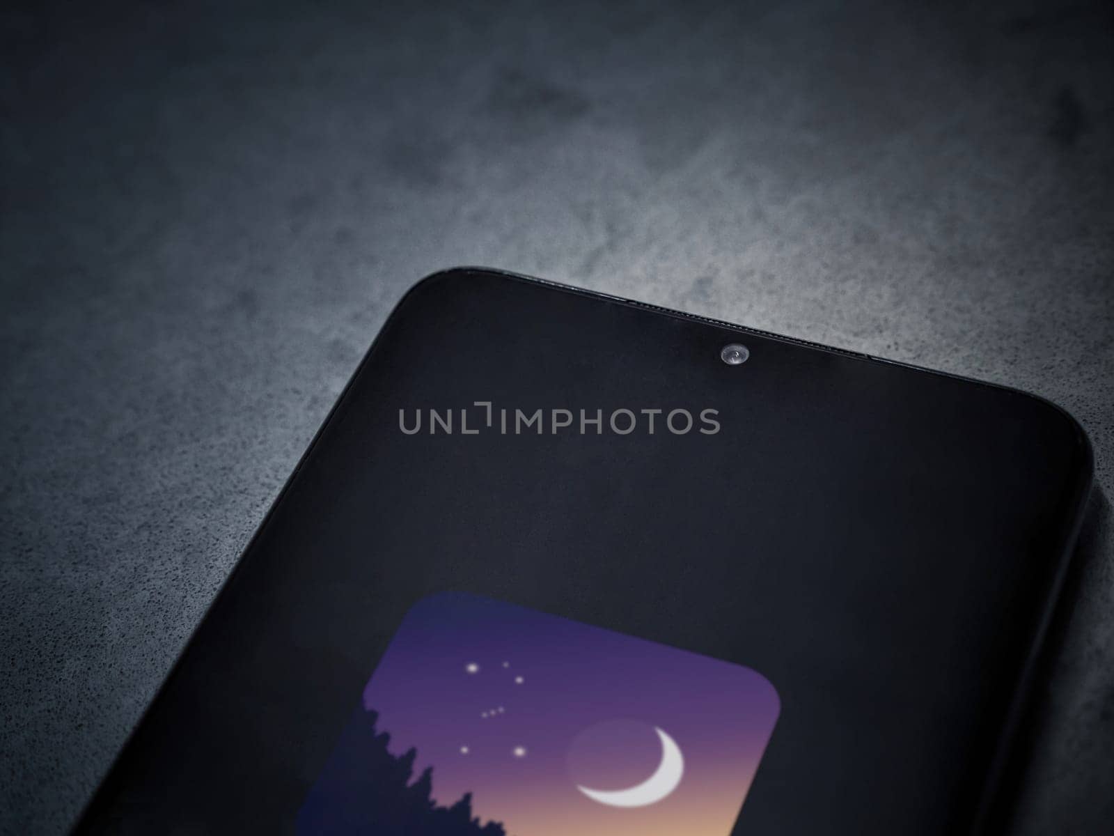 Lod, Israel - July 16,2023: Stellarium - Star Map app launch screen on smartphone on dark marble stone background. Top view flat lay with copy space.