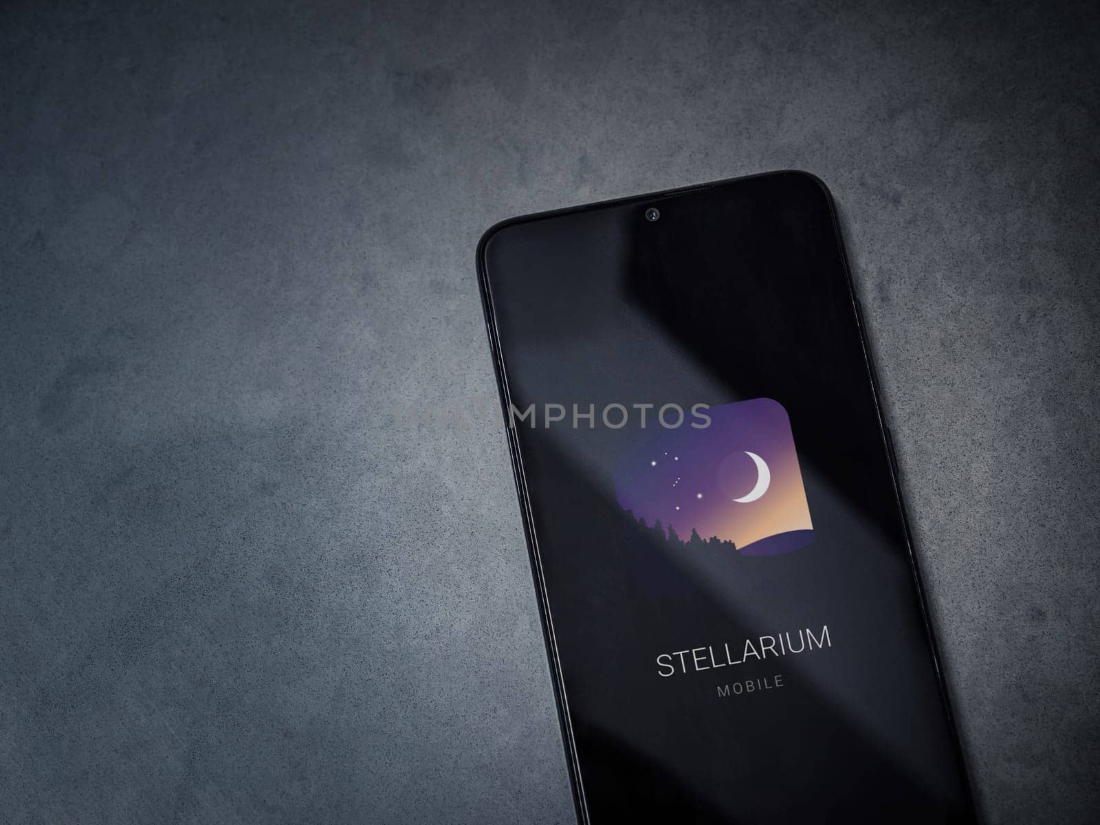 Lod, Israel - July 16,2023: Stellarium - Star Map app launch screen on smartphone on dark marble stone background. Top view flat lay with copy space.