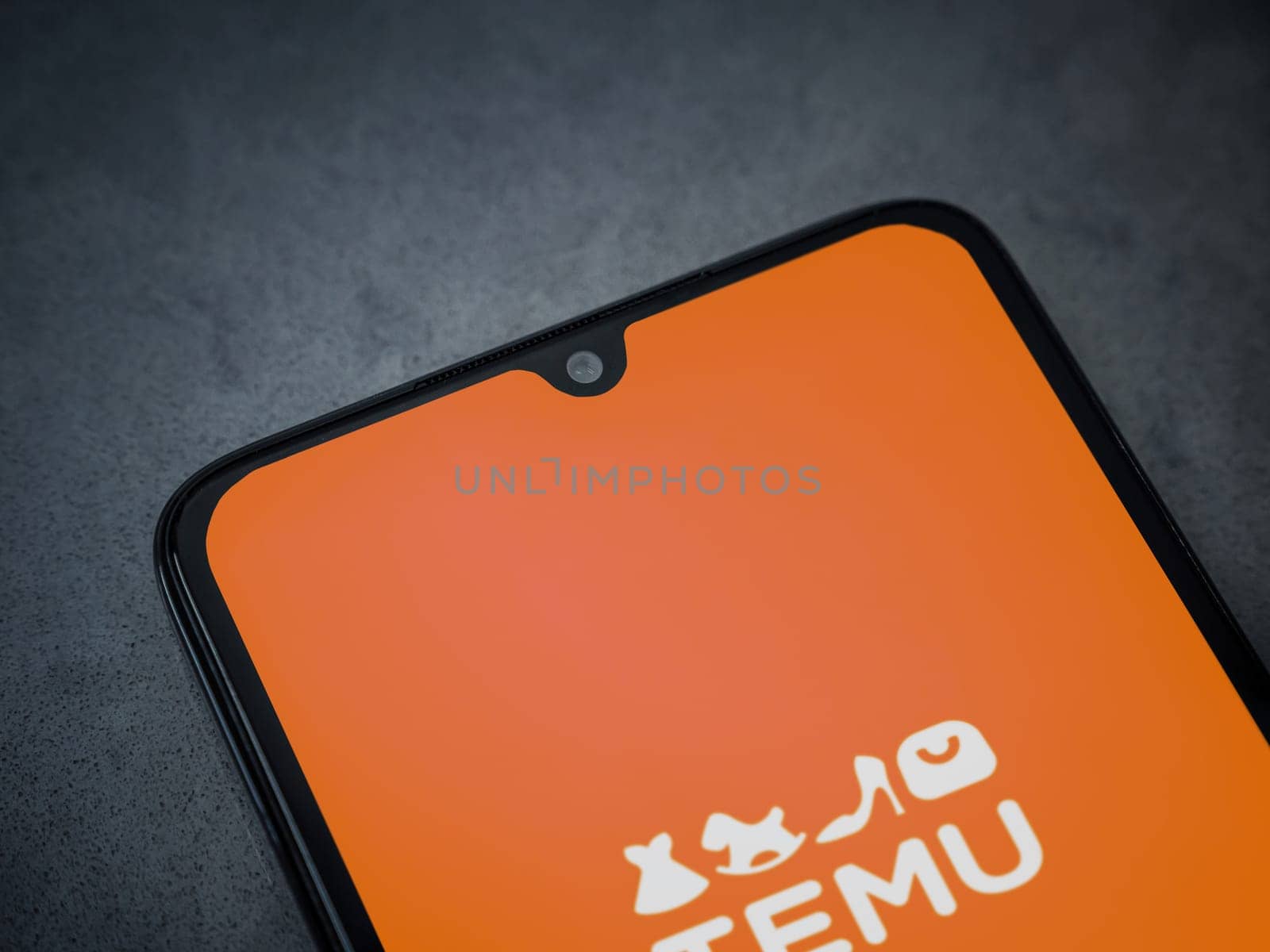 Lod, Israel - July 16,2023: Temu app launch screen on smartphone on dark marble stone background. Top view flat lay with copy space.