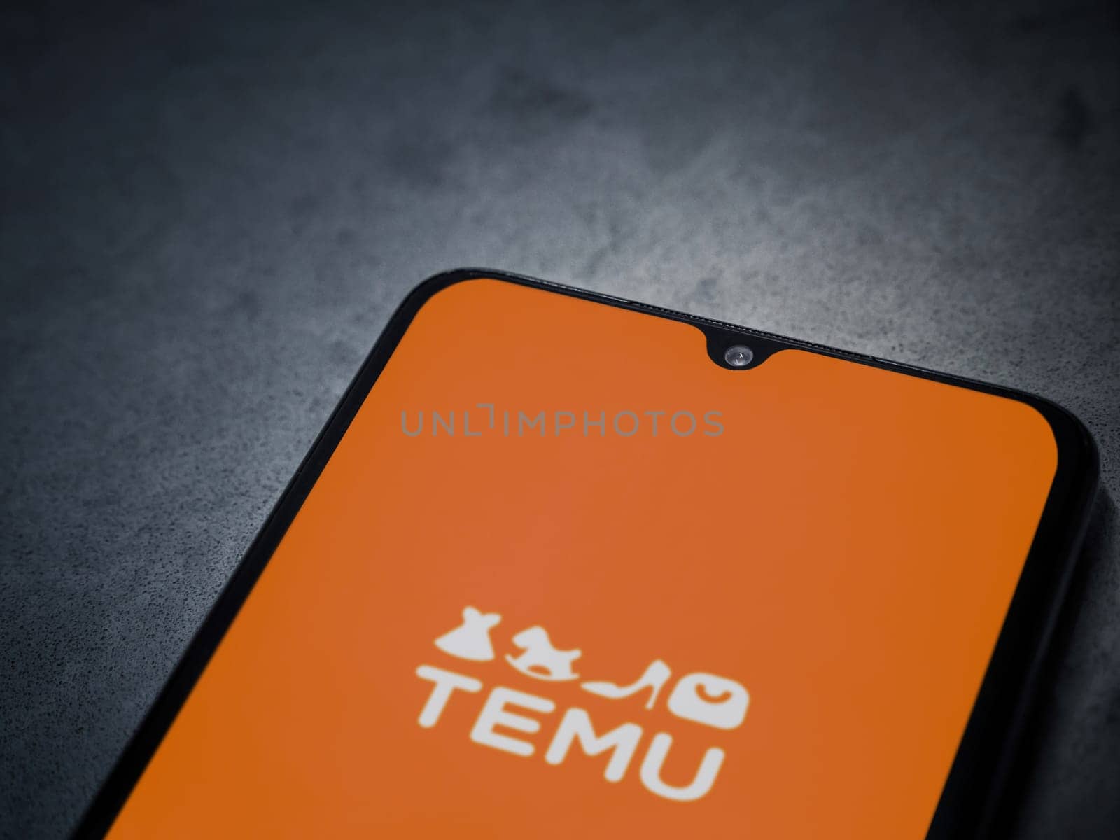 Lod, Israel - July 16,2023: Temu app launch screen on smartphone on dark marble stone background. Top view flat lay with copy space.
