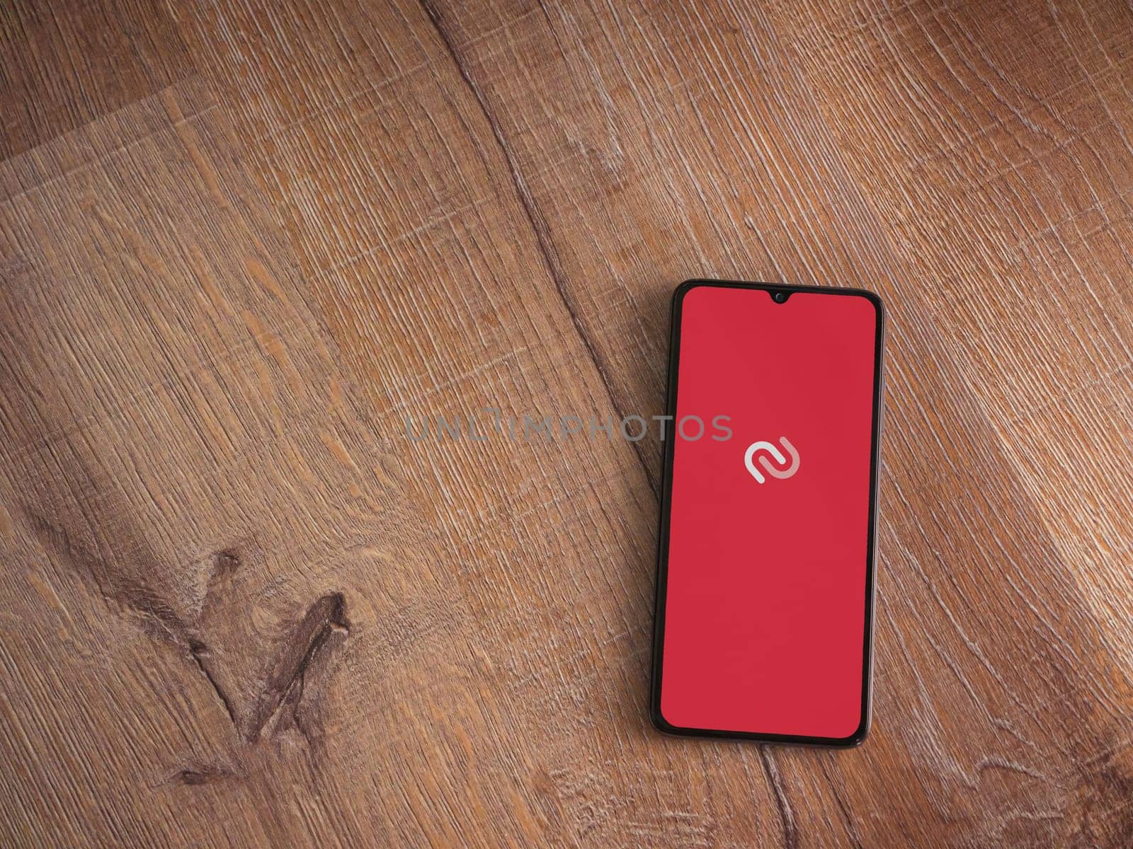 Lod, Israel - July 16,2023: Twilio Authy Authenticator app launch screen on smartphone on wooden background. Top view flat lay with copy space.