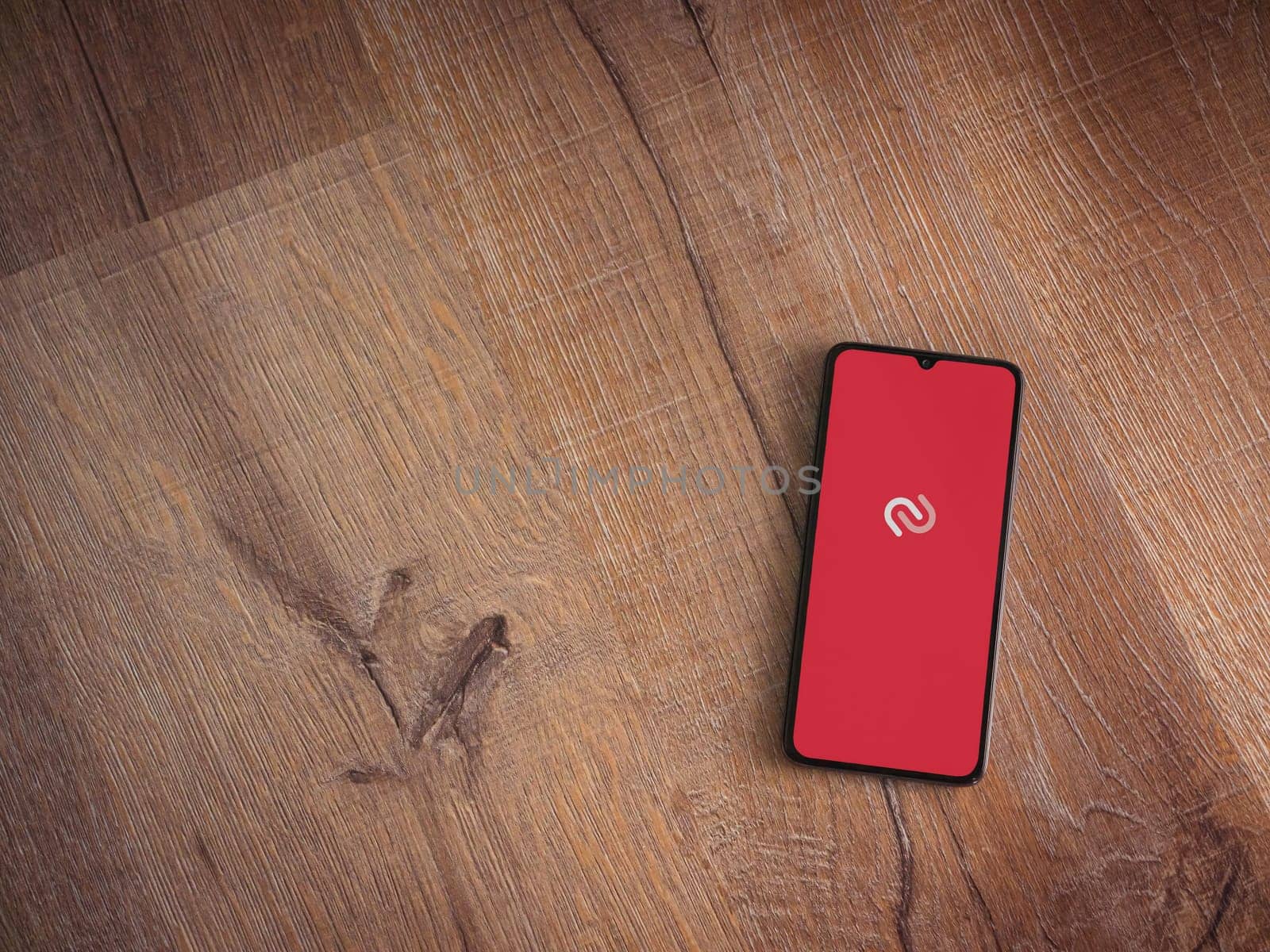 Lod, Israel - July 16,2023: Twilio Authy Authenticator app launch screen on smartphone on wooden background. Top view flat lay with copy space.