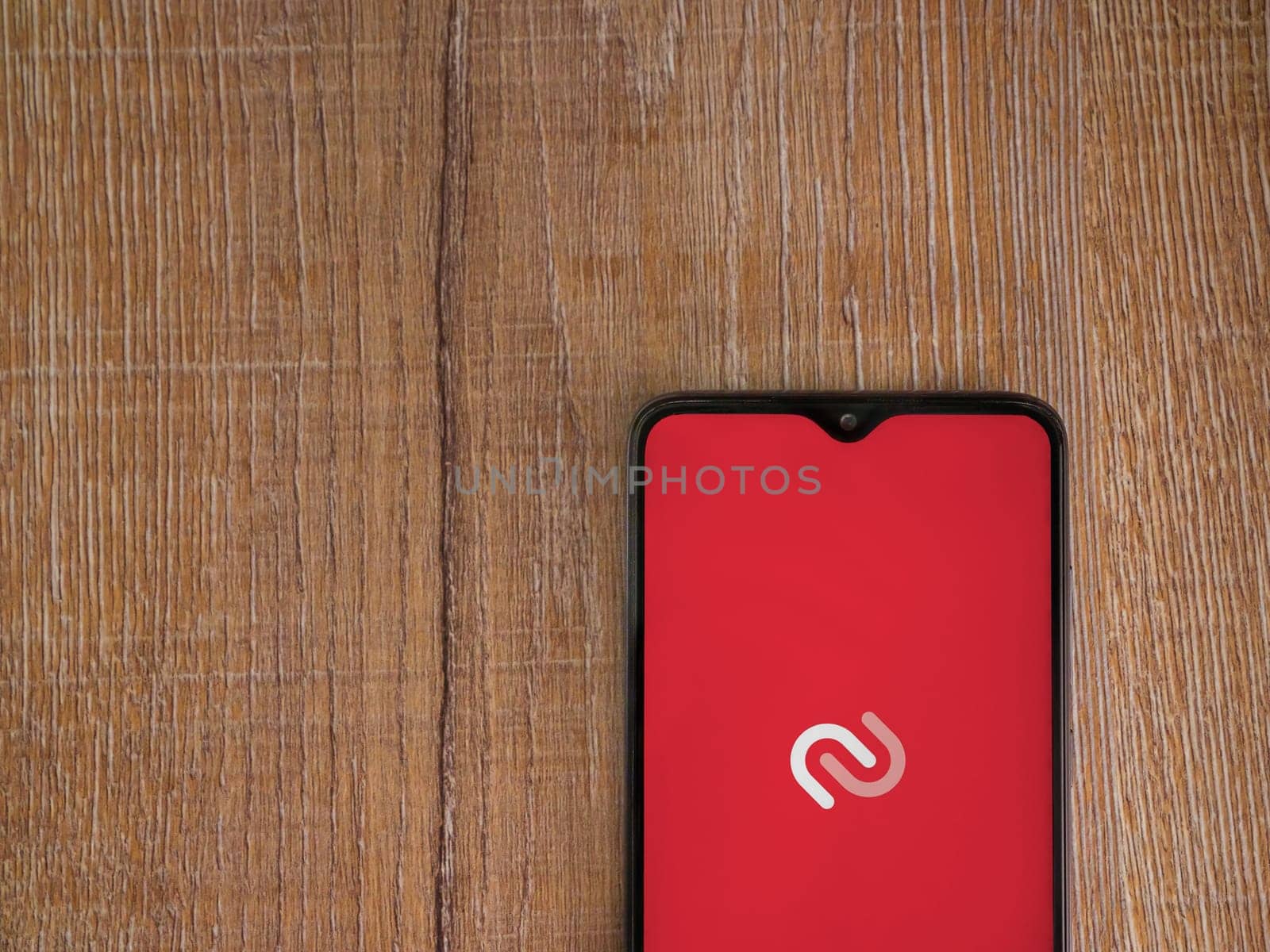 Lod, Israel - July 16,2023: Twilio Authy Authenticator app launch screen on smartphone on wooden background. Top view flat lay with copy space.