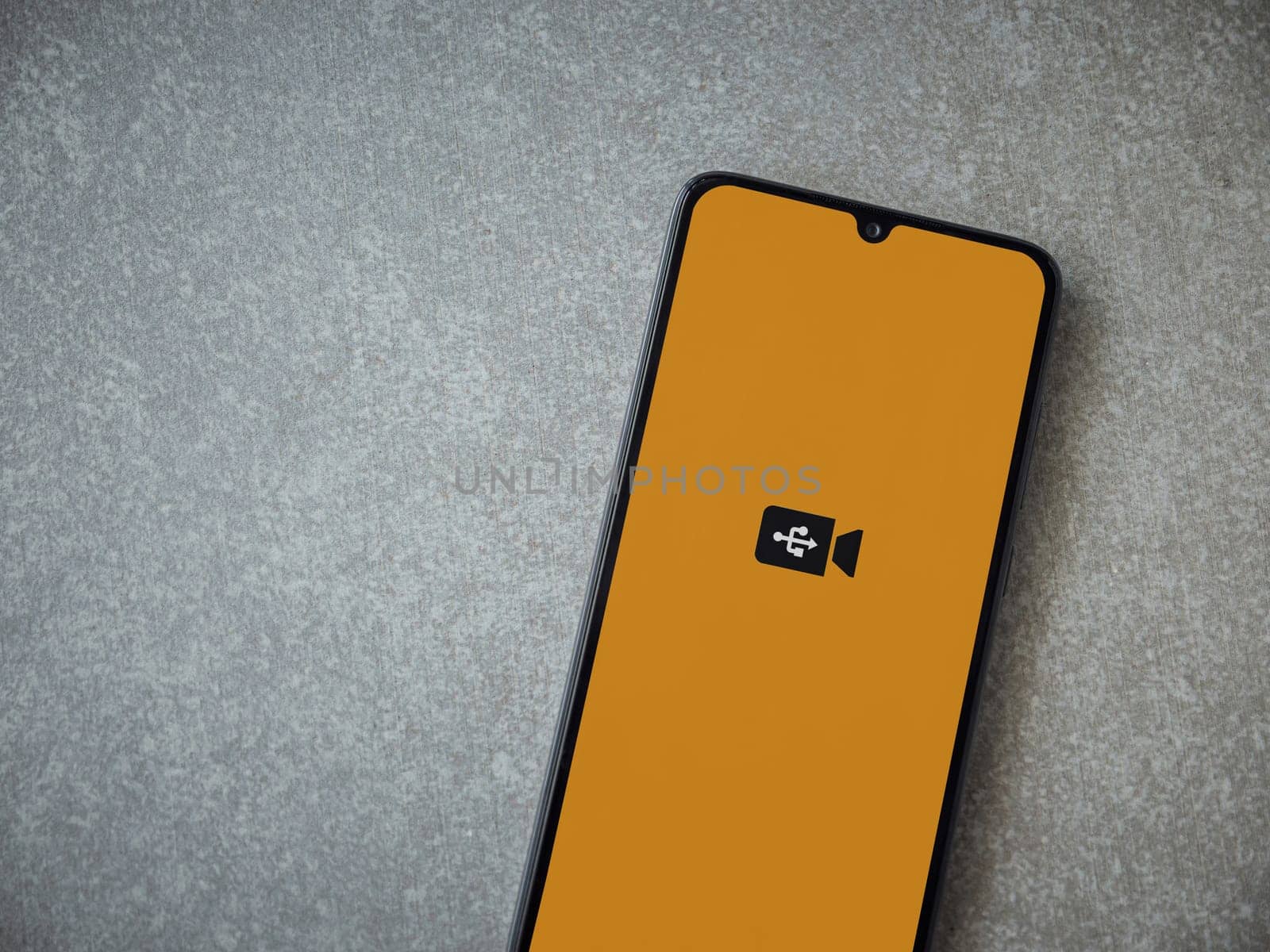 Lod, Israel - July 16,2023: USB Camera app launch screen on smartphone on ceramic stone background. Top view flat lay with copy space.