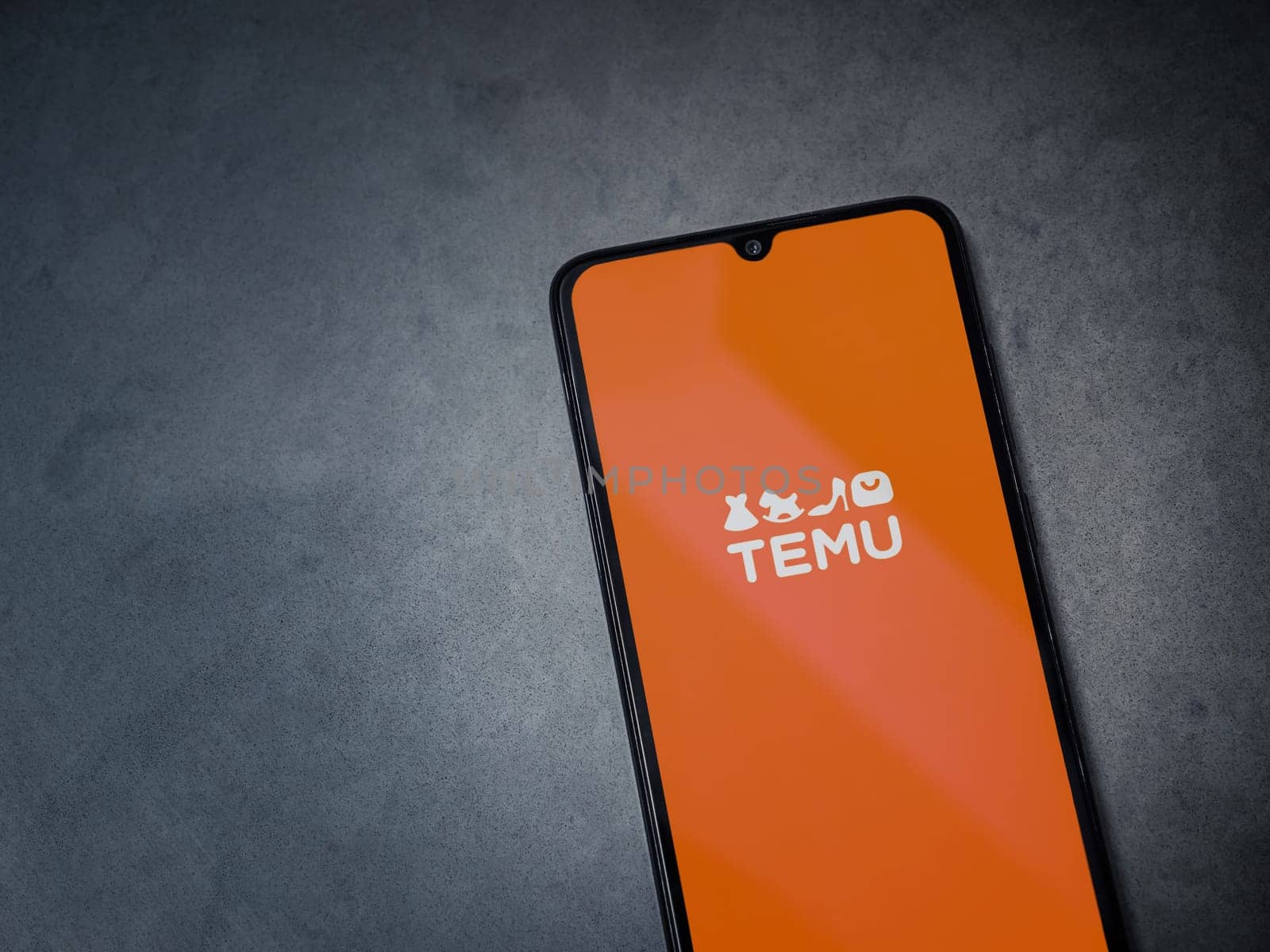Lod, Israel - July 16,2023: Temu app launch screen on smartphone on dark marble stone background. Top view flat lay with copy space.