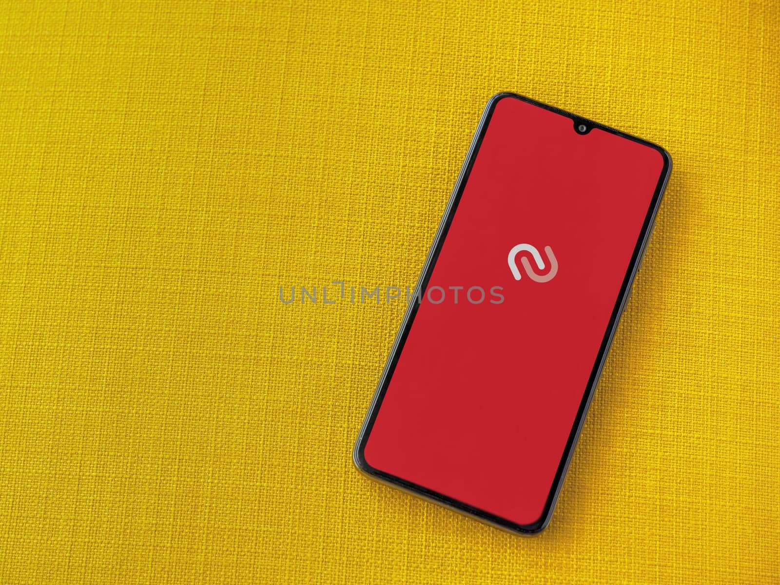 Lod, Israel - July 16,2023: Twilio Authy Authenticator app launch screen on smartphone on yellow fabric background. Top view flat lay with copy space.