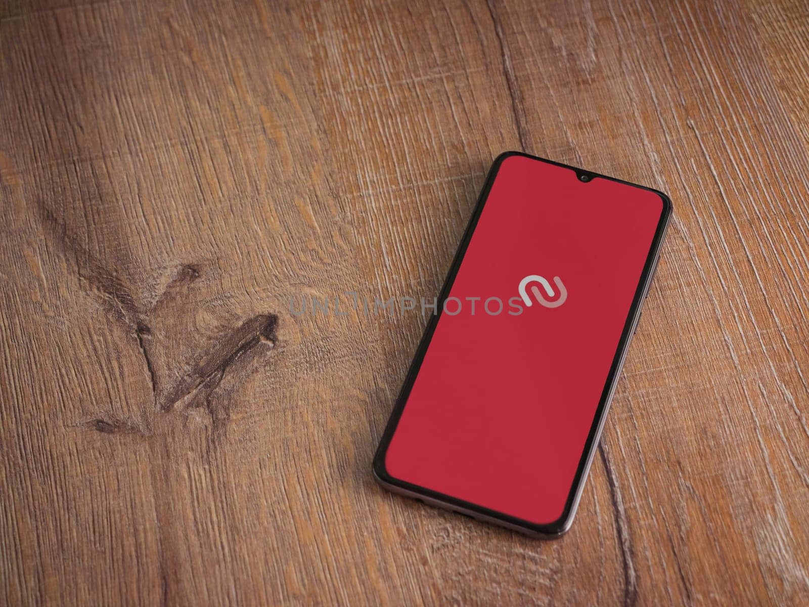 Lod, Israel - July 16,2023: Twilio Authy Authenticator app launch screen on smartphone on wooden background. Top view flat lay with copy space.