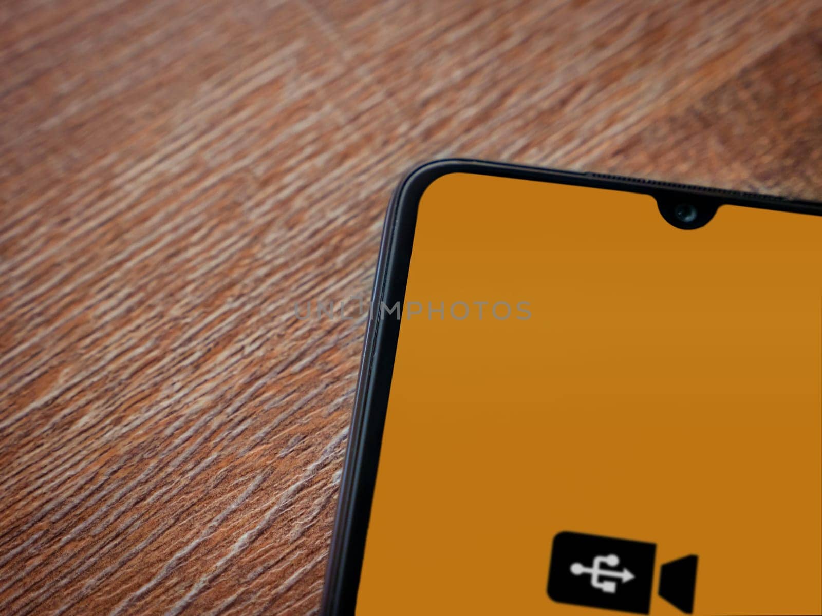Lod, Israel - July 16,2023: USB Camera app launch screen on smartphone on wooden background. Top view flat lay with copy space.