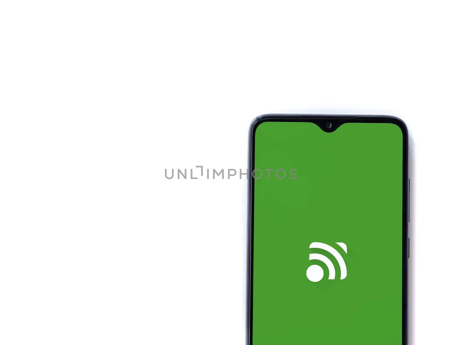 Lod, Israel - July 16,2023: Unified Remote app launch screen on smartphone on white background. Top view flat lay with copy space.