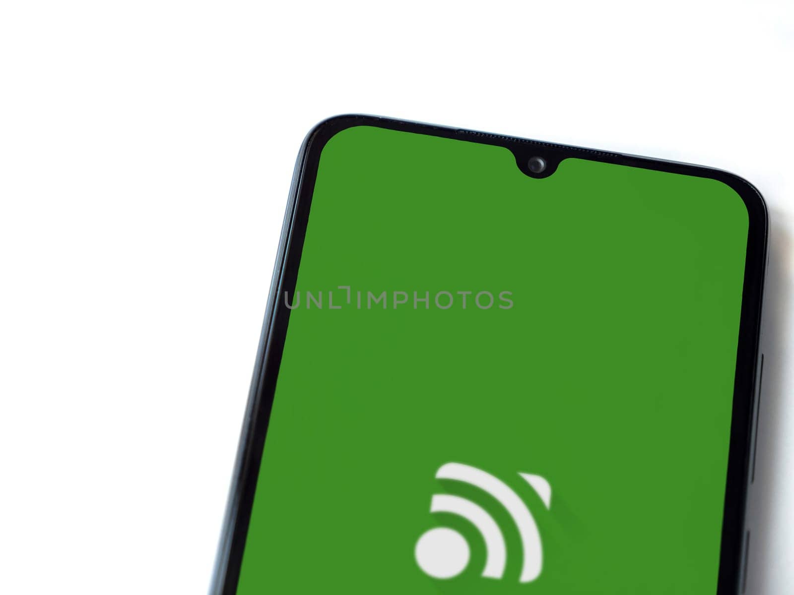 Lod, Israel - July 16,2023: Unified Remote app launch screen on smartphone on white background. Top view flat lay with copy space.