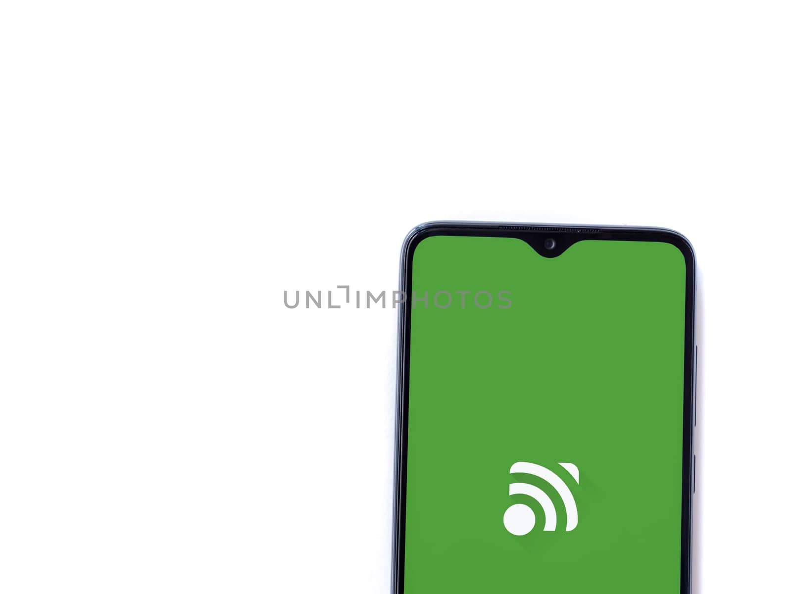 Lod, Israel - July 16,2023: Unified Remote app launch screen on smartphone on white background. Top view flat lay with copy space.