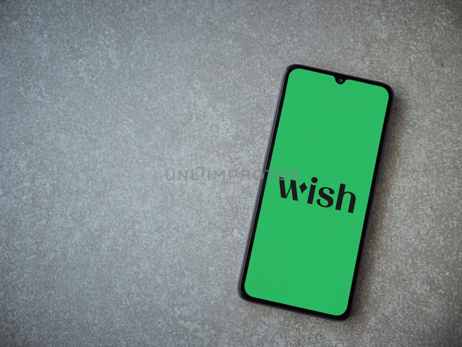 Lod, Israel - July 16,2023: Wish app launch screen on smartphone on ceramic stone background. Top view flat lay with copy space.